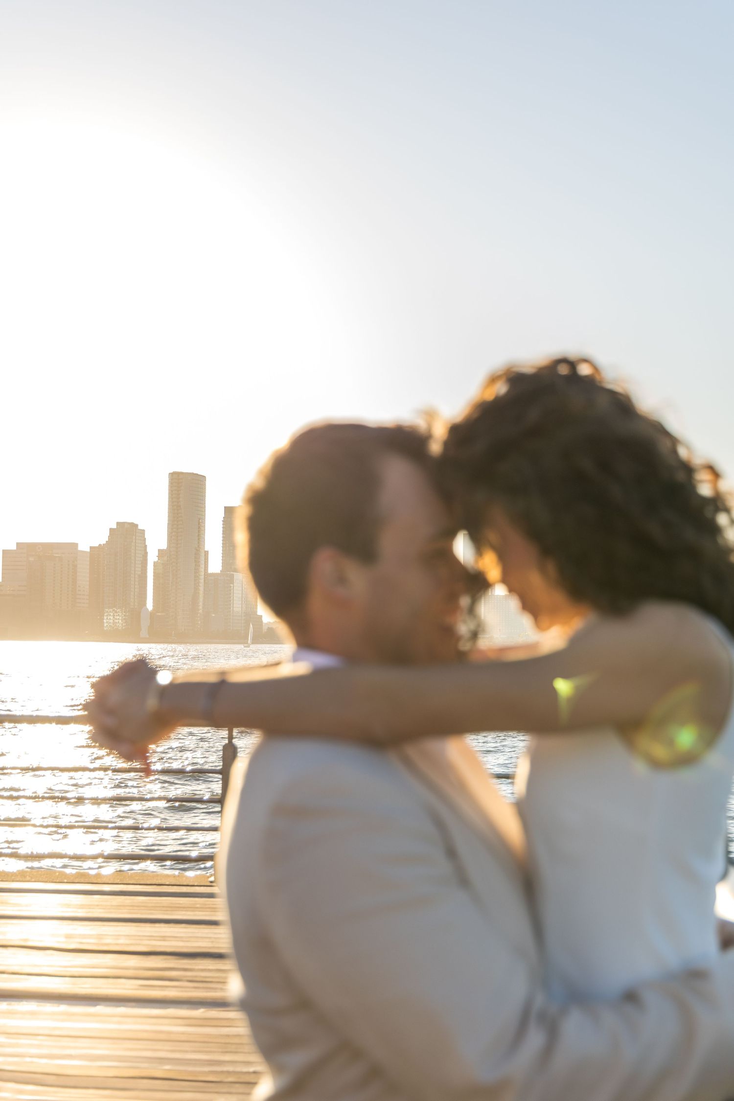 Silhouetted couple embracing at Pier 45 during sunset, with the hudson river in the bakground