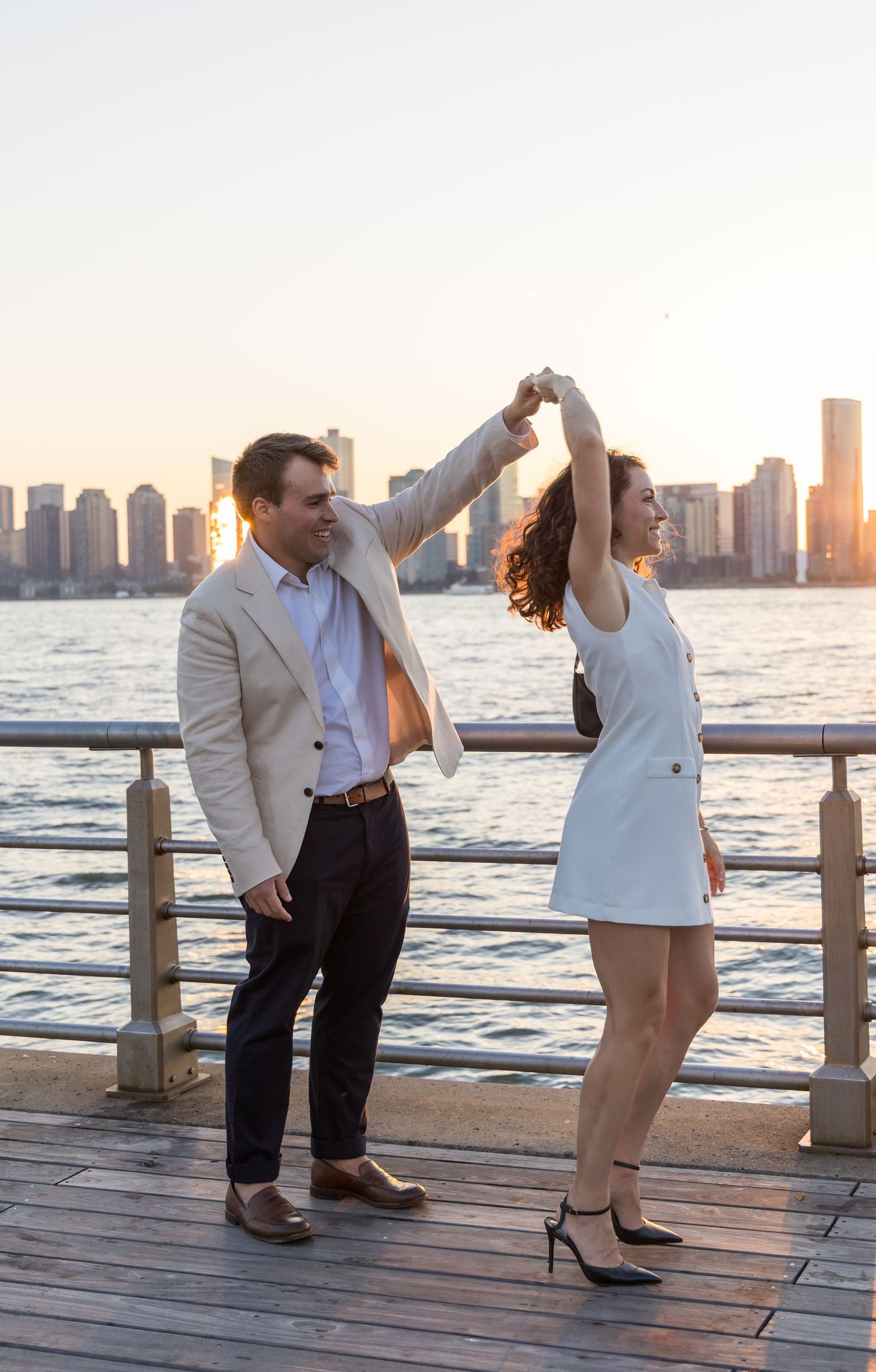 Man spinning his fiance at pier 45 in nyc engagement photoshoot