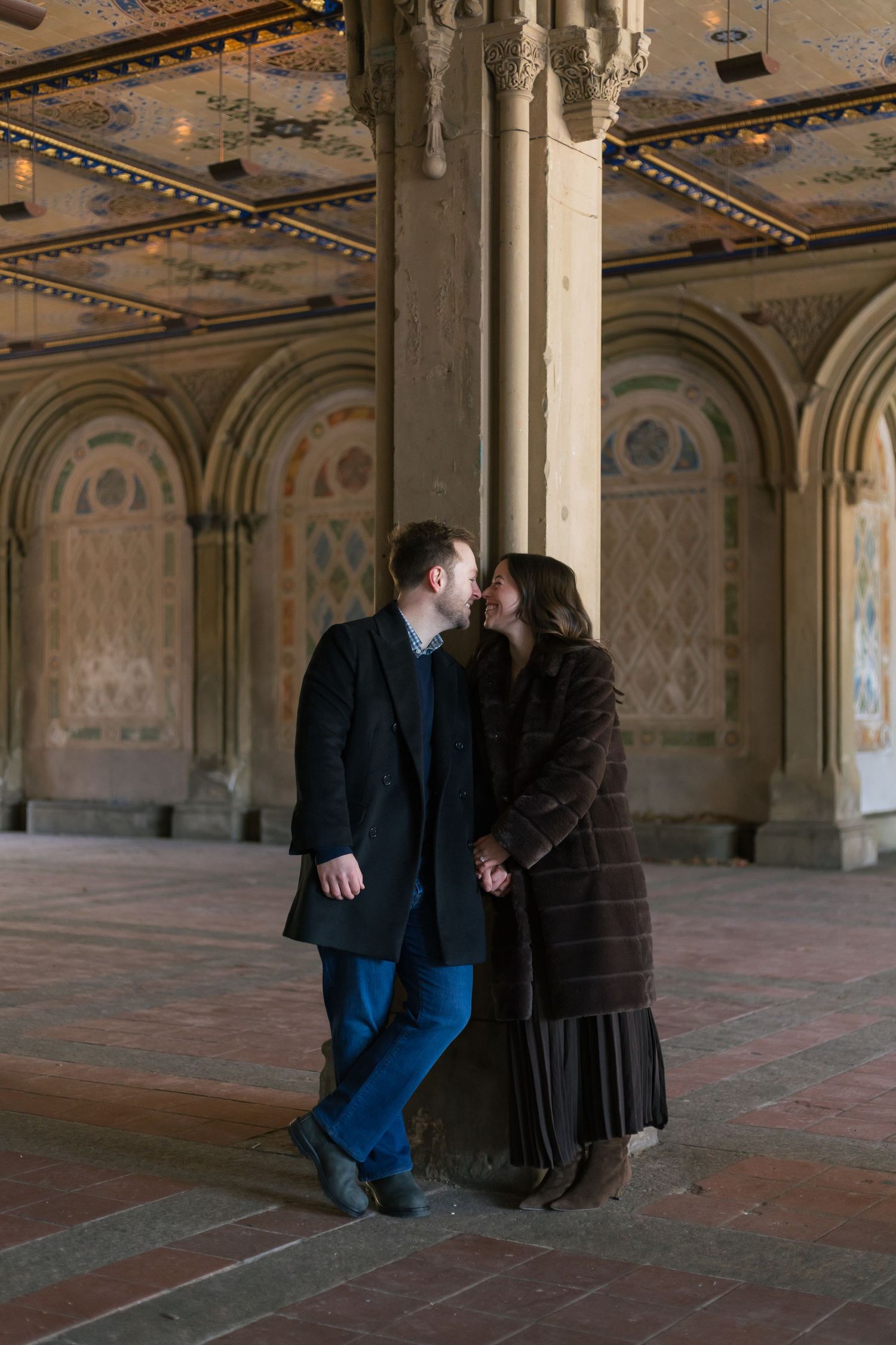 A couple shares a kiss at a pillar under Bethesda Terrace in NYC.