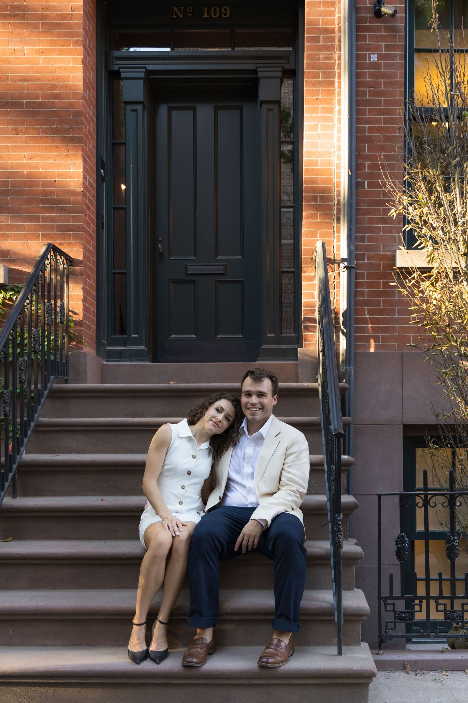 NYC Couple sitting on West Village Brownstone steps during golden hour