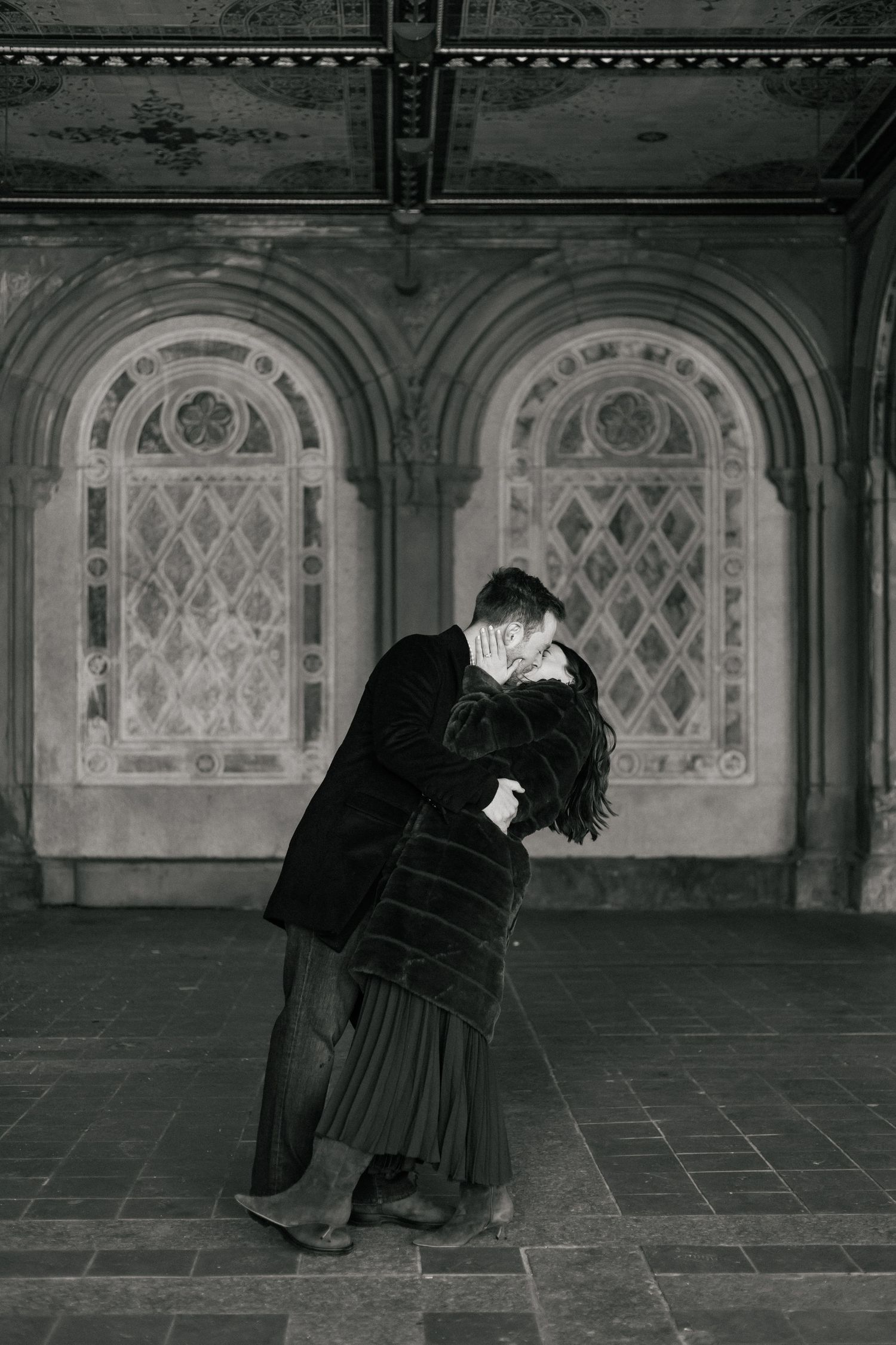 Intimate black and white photograph of a couple in kissing at Bethesda Terrace