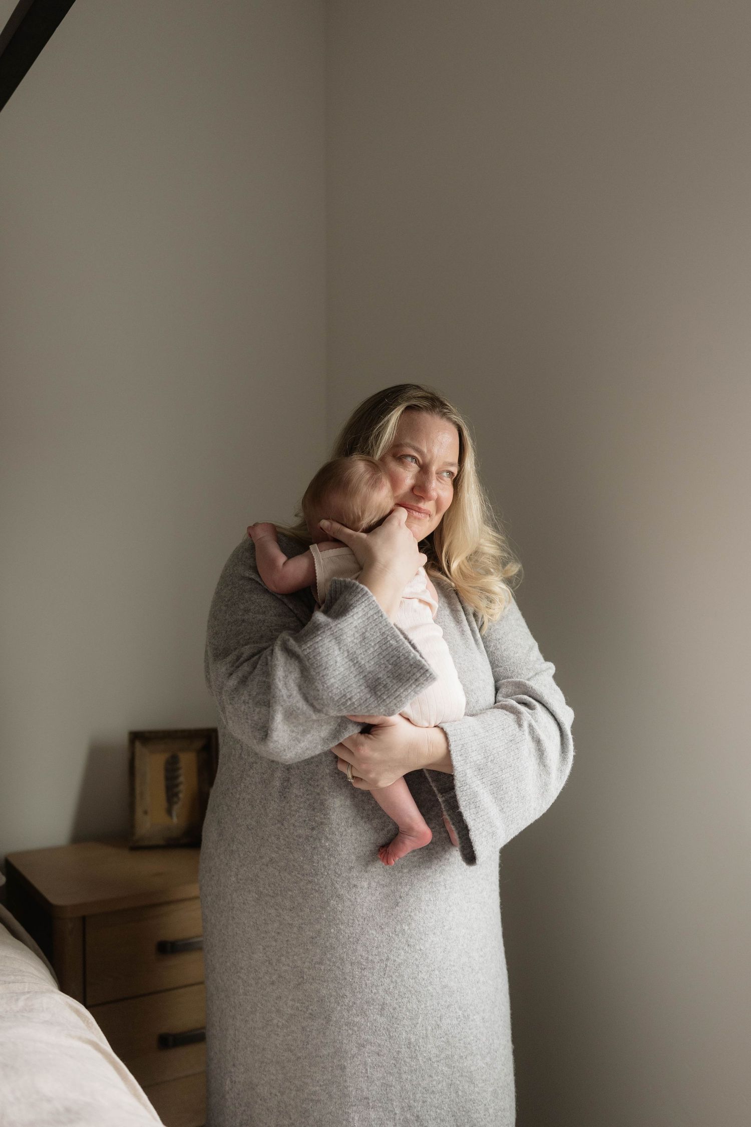 A person in a cozy gray sweater poses against a neutral wall in a sequence of artistic self-portrait photographs.