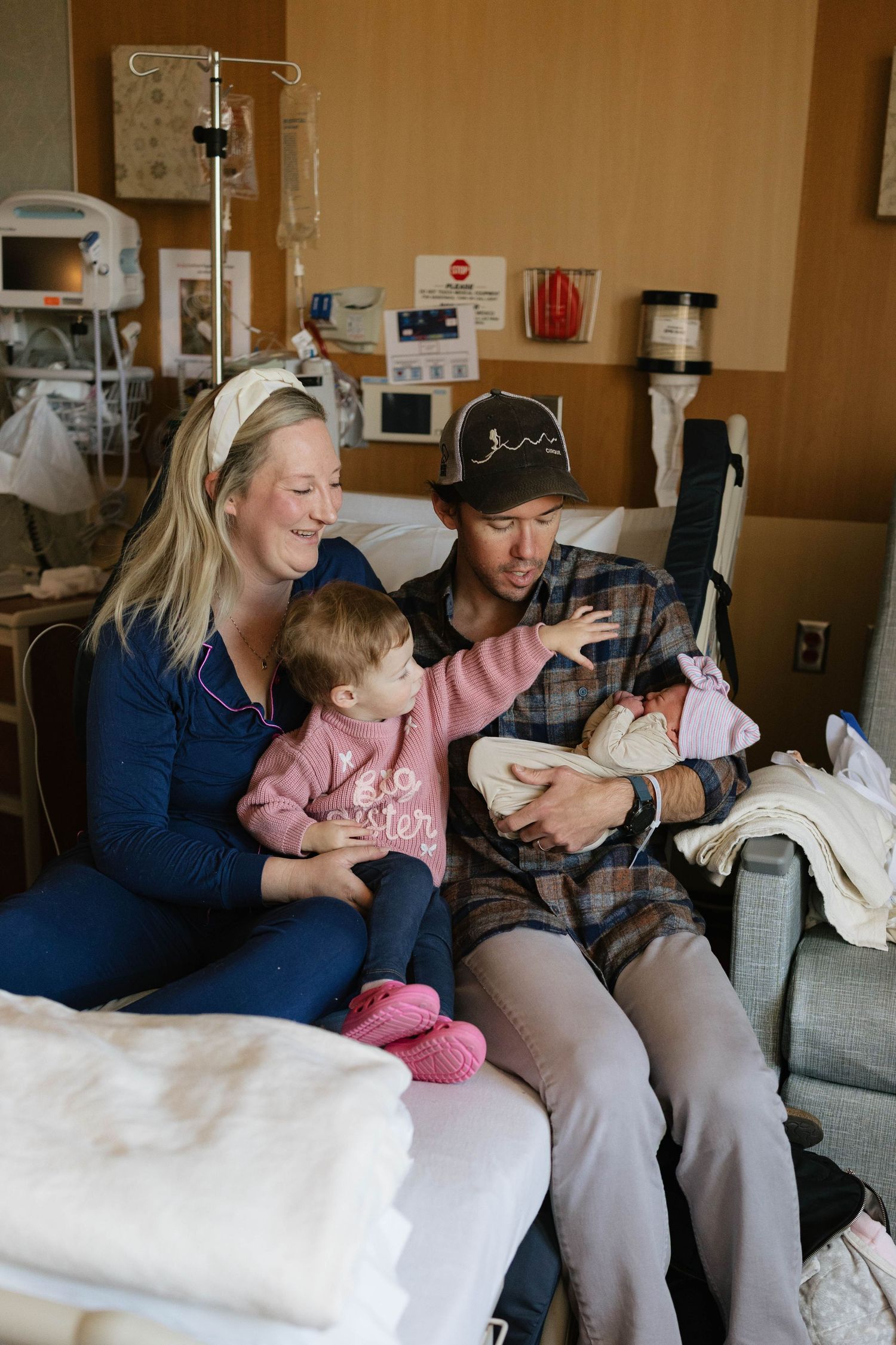 Family sharing intimate moment together in hospital room after birth.