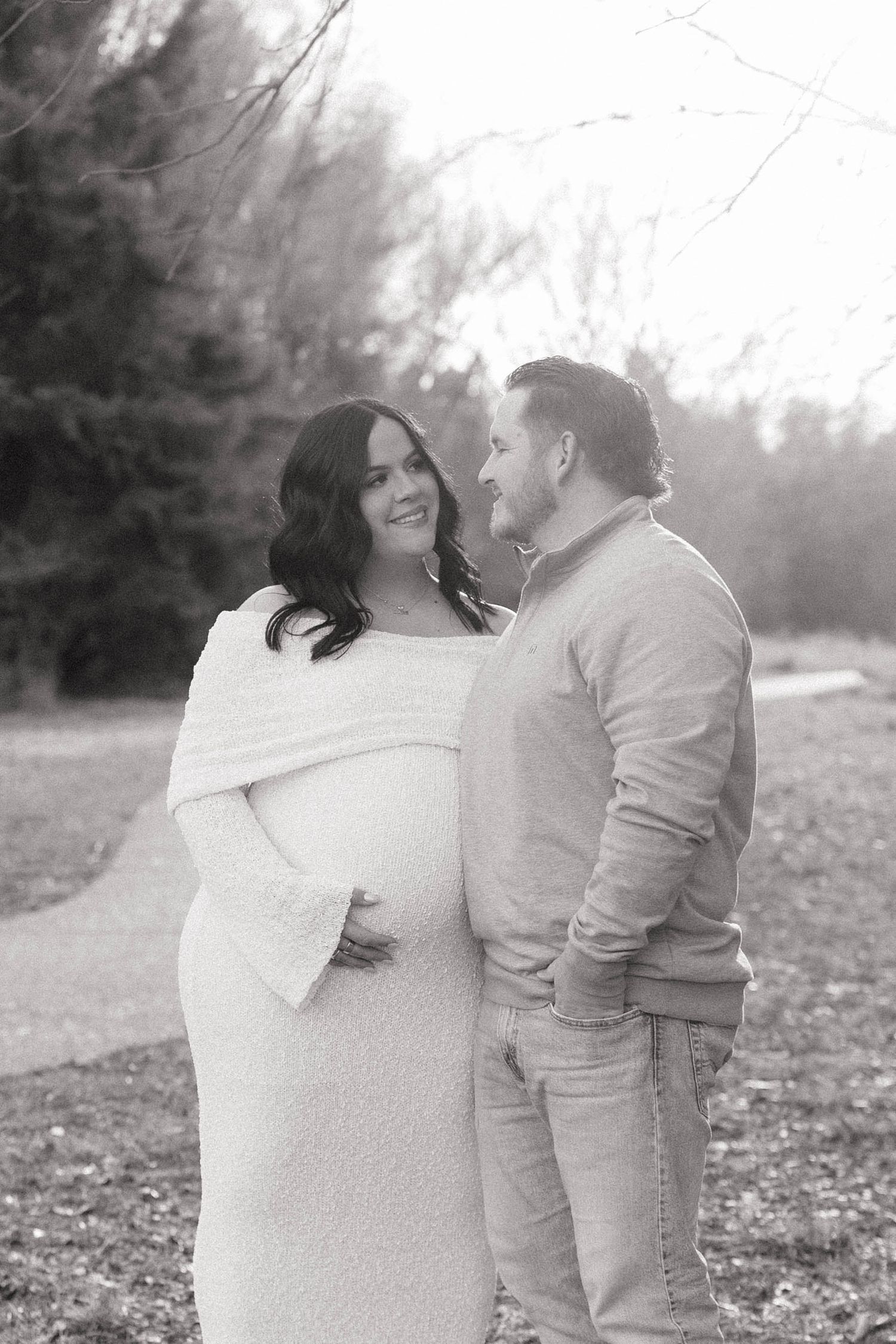 A romantic couple shares tender moments in a misty outdoor setting wearing neutral tones during a photo session.