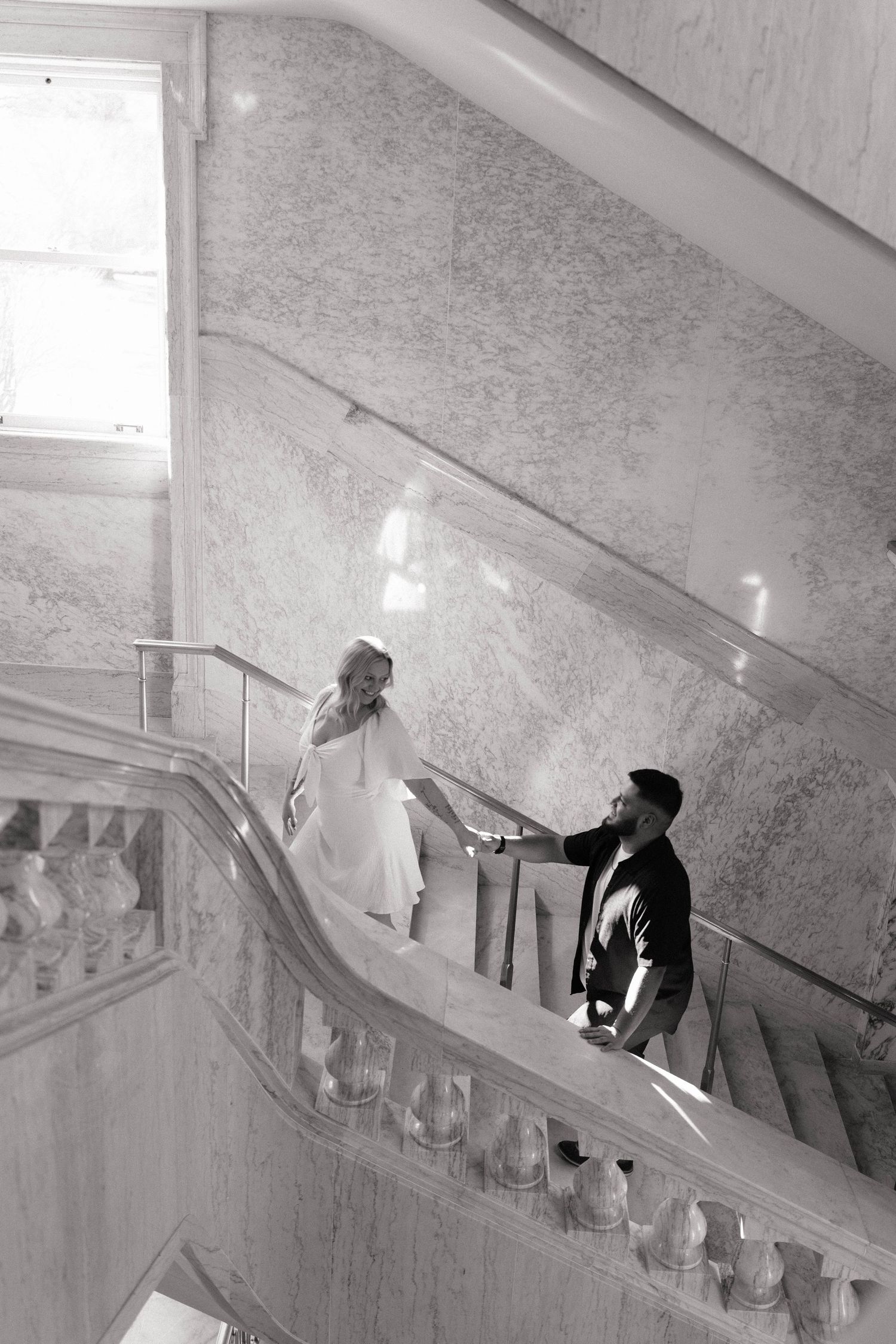 A sequence of black and white surveillance camera images showing someone walking down a stairwell.