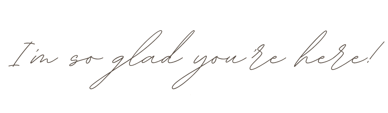 Handwritten cursive text reading 'I'm so glad you're here!' in light gray ink.
