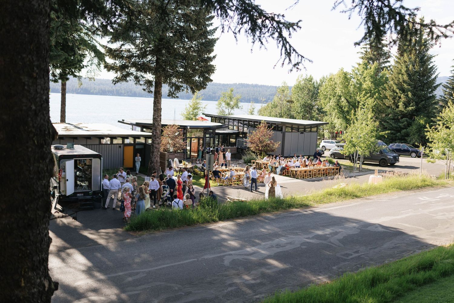 Panoramic view of a lakeside resort area with trees, buildings and outdoor recreational spaces.