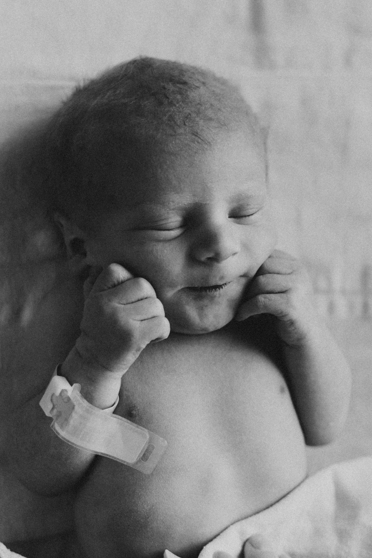 Black and white close-up portrait of sleeping newborn baby.