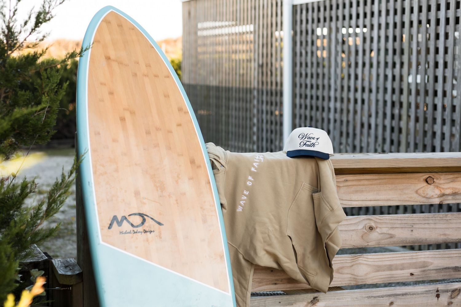 Surfboards leaning against a wooden bench with a building in the background.