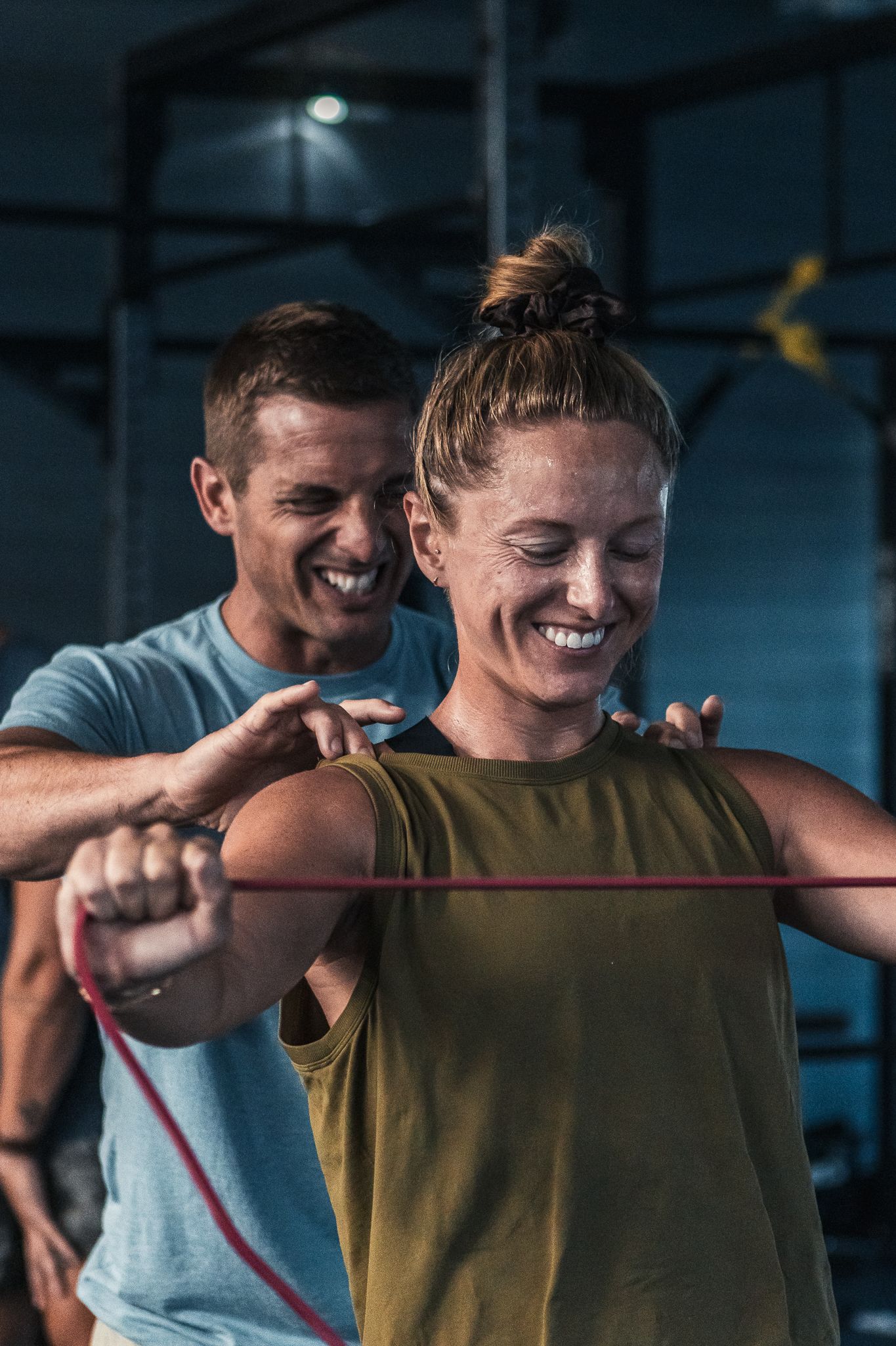 Training session in a dimly lit gym with fitness equipment.