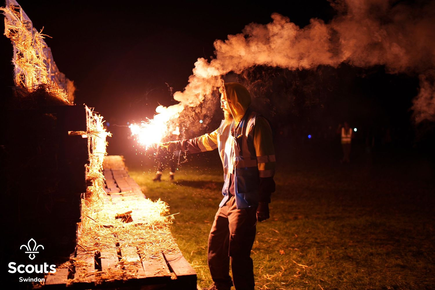 A man lighting a bonfire with a marine flair