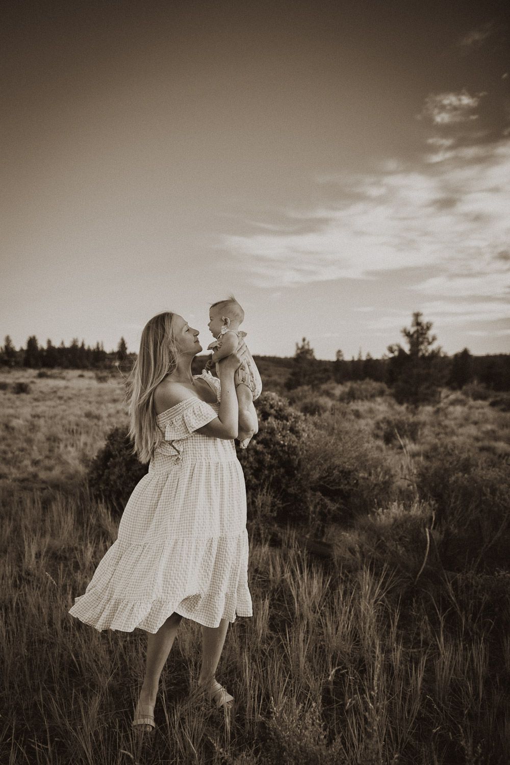 Black and white portrait session in a rustic field setting with flowing white dresses.