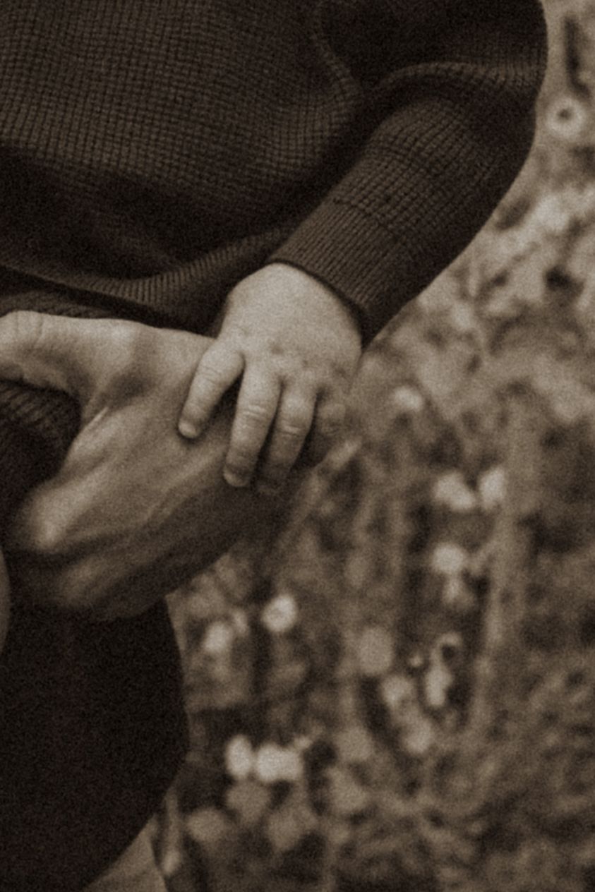 Close-up detail shot of hands touching in black and white.