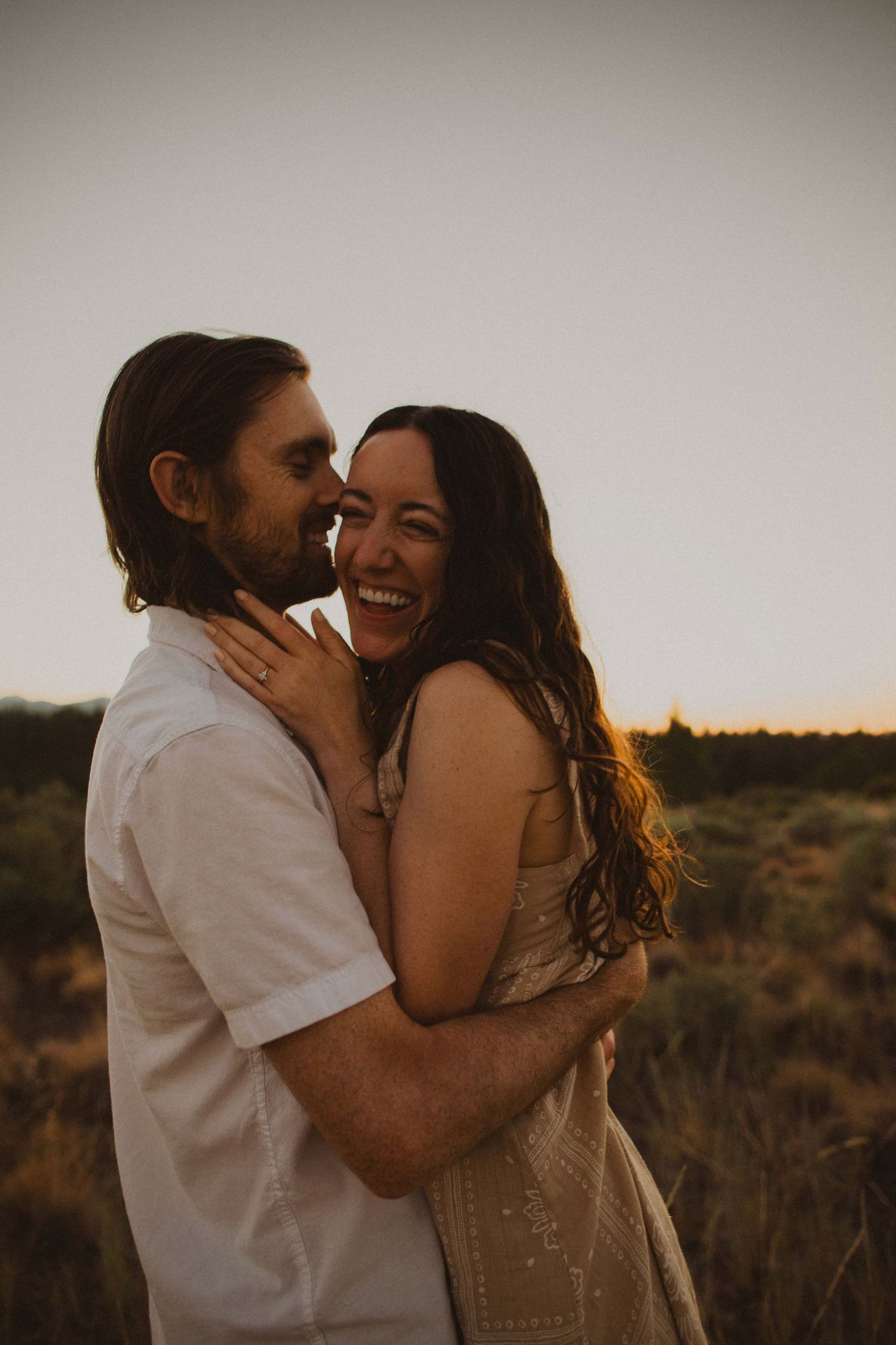 A couple shares playful and tender moments in golden desert light.