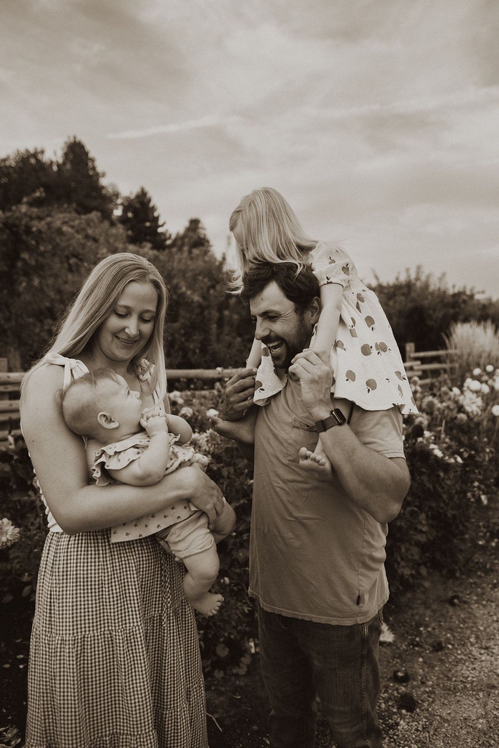 Sweet family moments captured in a garden setting with flowers blooming.