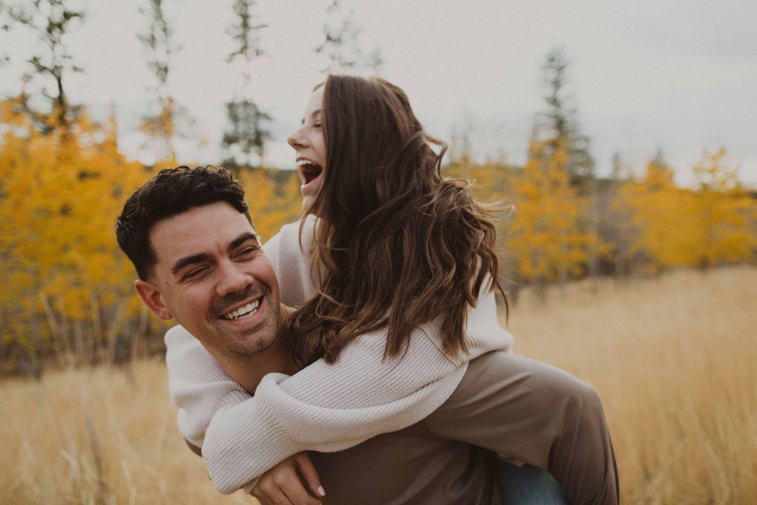 A joyful outdoor photoshoot with autumn colors and natural scenery in the background.