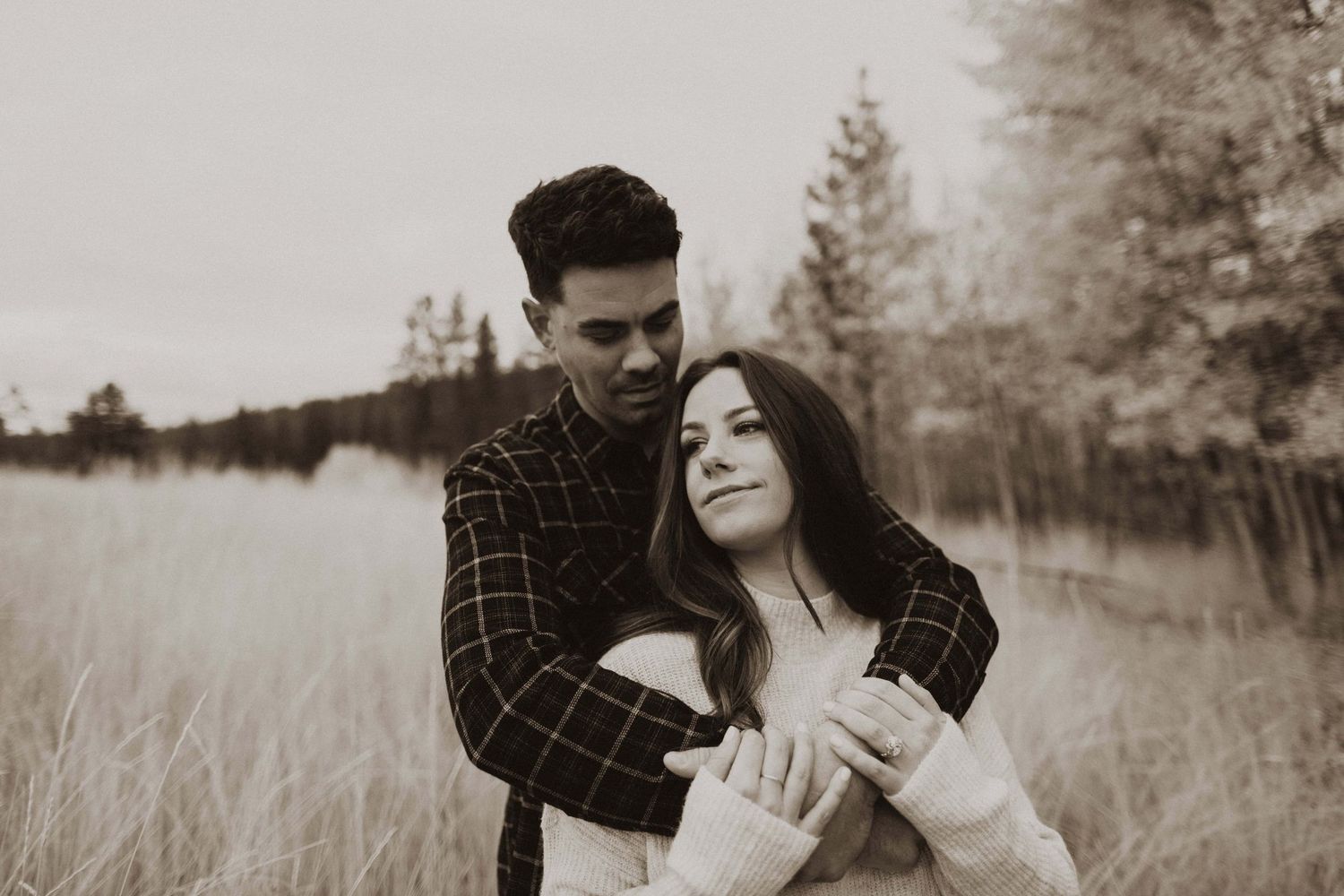 Romantic couple sharing tender moment in rustic outdoor setting.