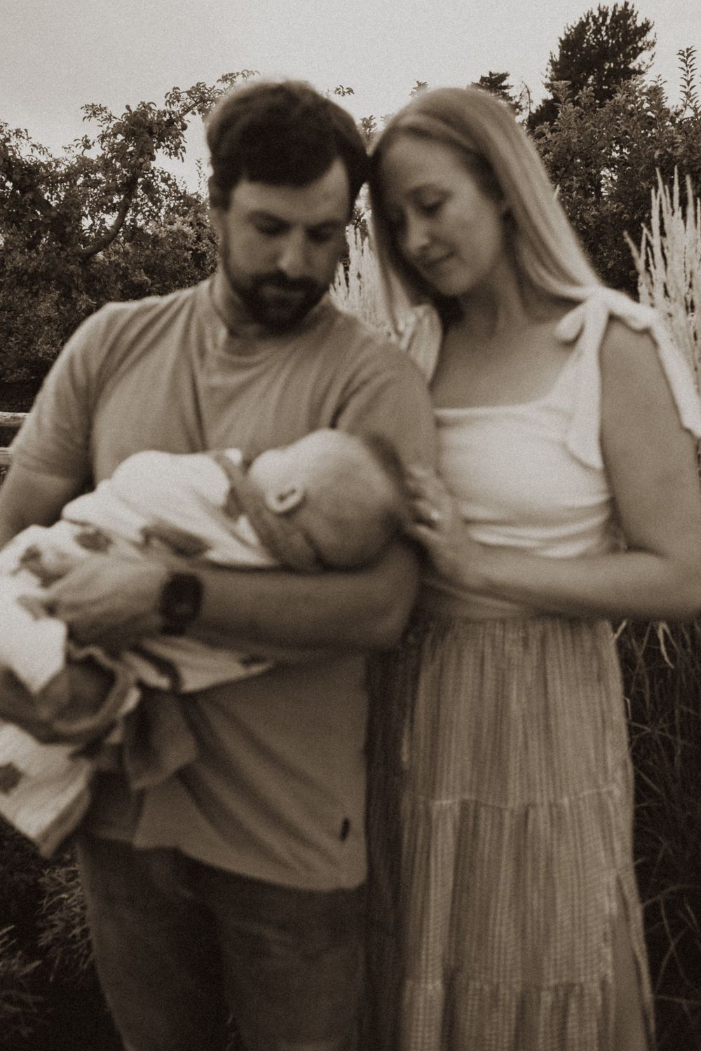 Intimate family moments captured in black and white outdoors.