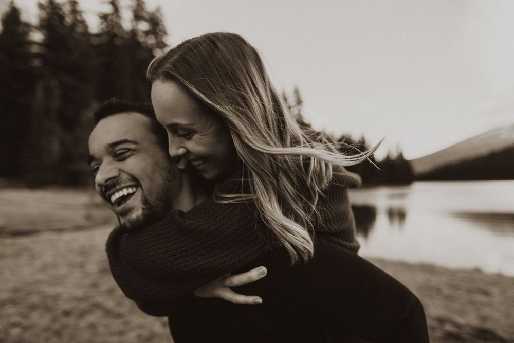 Black and white photo series of a couple laughing and embracing outdoors.