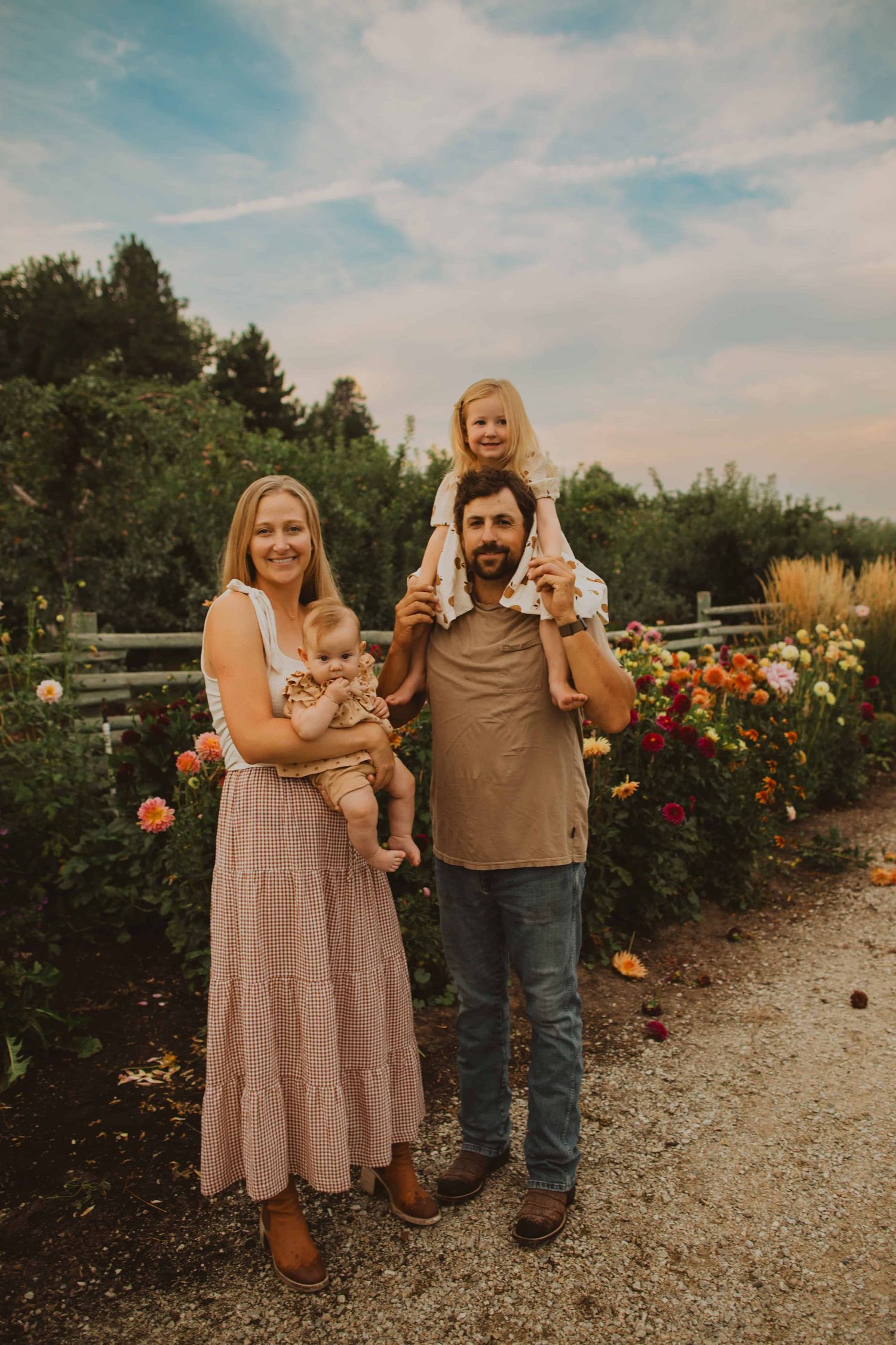 A family shares joyful moments together in a beautiful flower garden on a sunny afternoon.