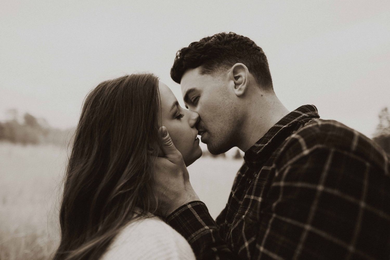 Intimate black and white portrait of couple in close embrace.
