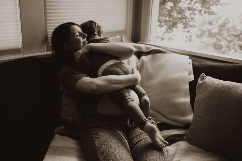Intimate indoor portrait with natural window lighting and soft shadows.