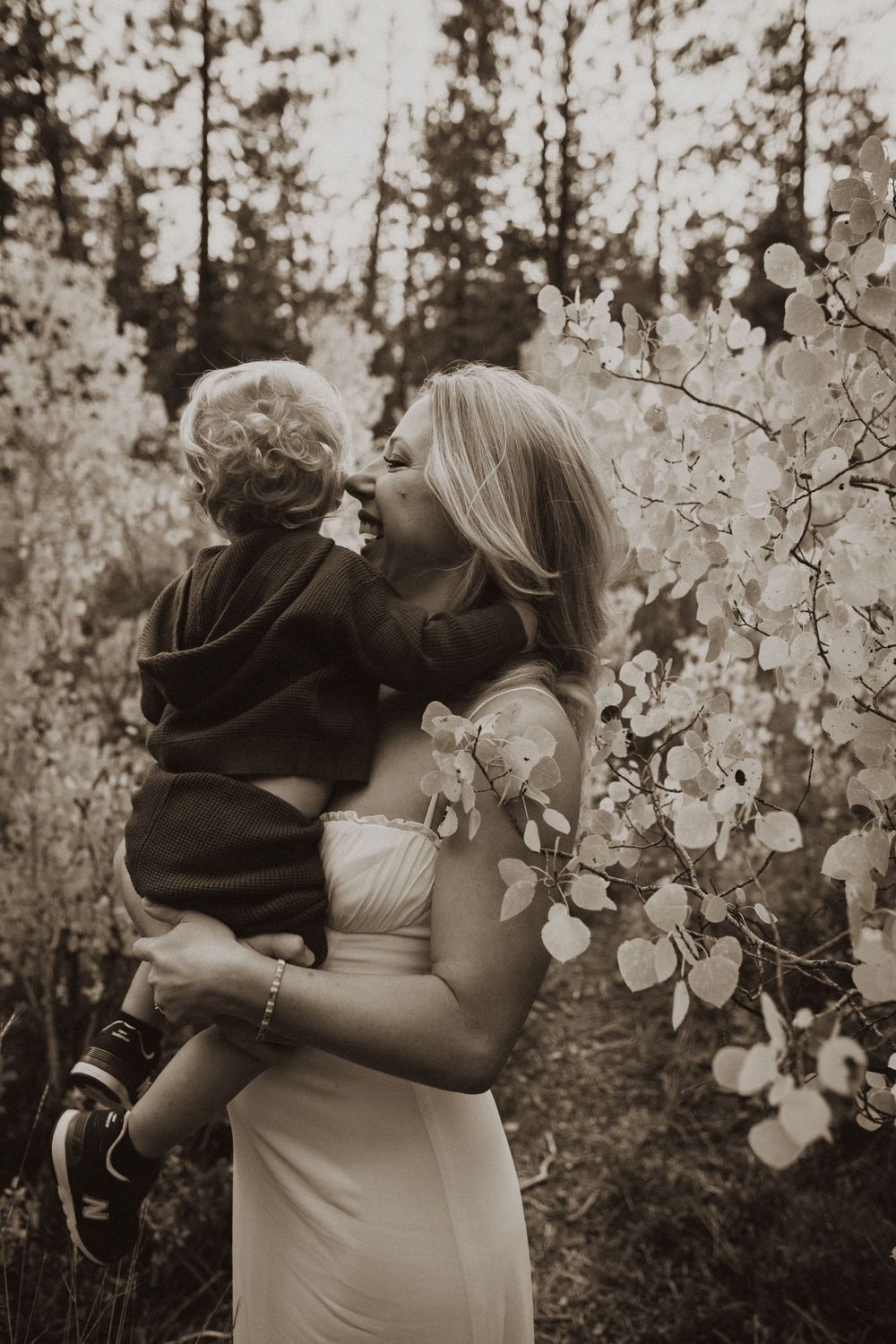 Intimate family portrait surrounded by delicate white aspen leaves in nature.