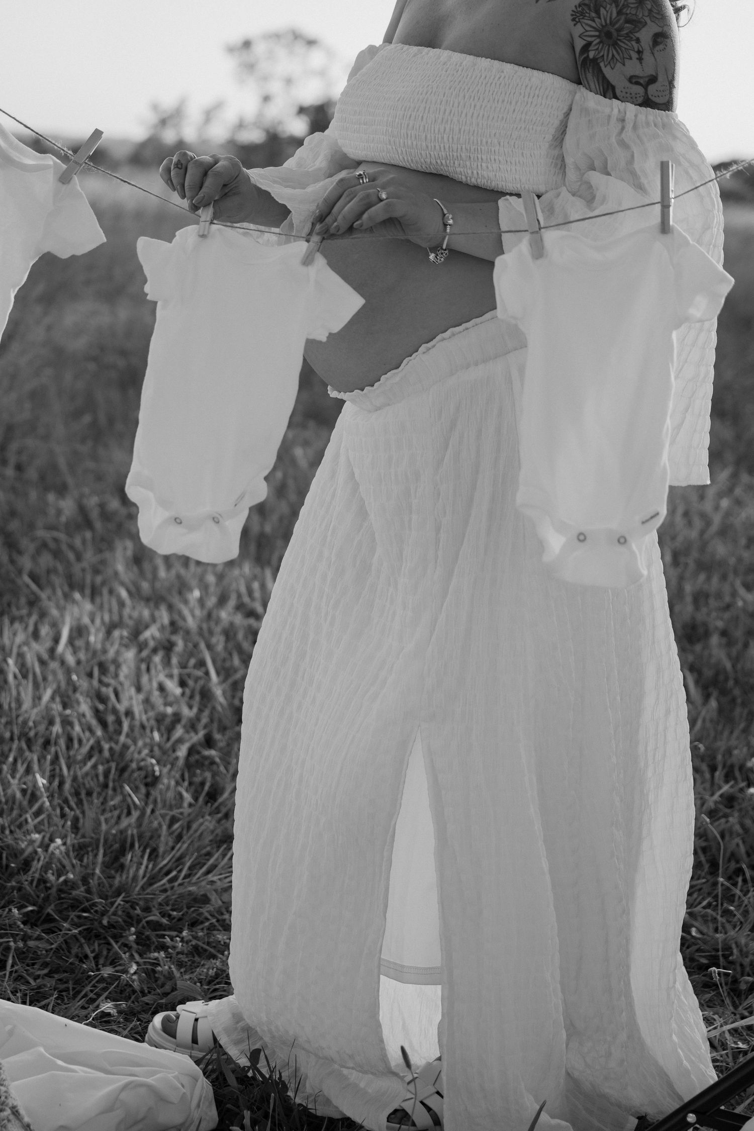 Black and white photos of white baby clothes hanging on a clothesline.