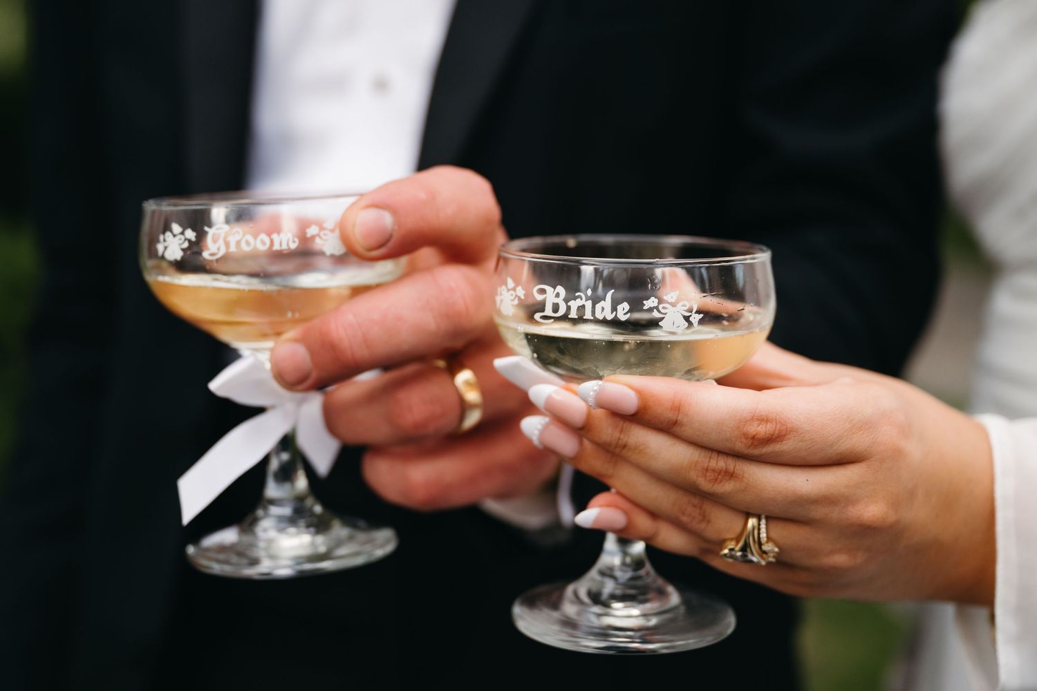 Wedding champagne glasses being held and toasted in celebration.