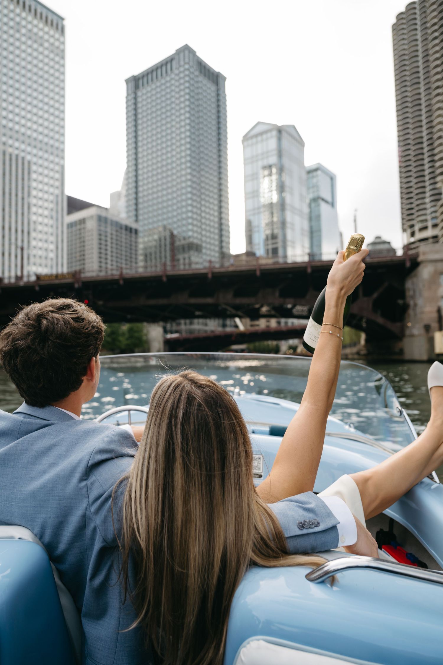 Couple enjoying a boat ride on the river with Chicago skyline in the background.
