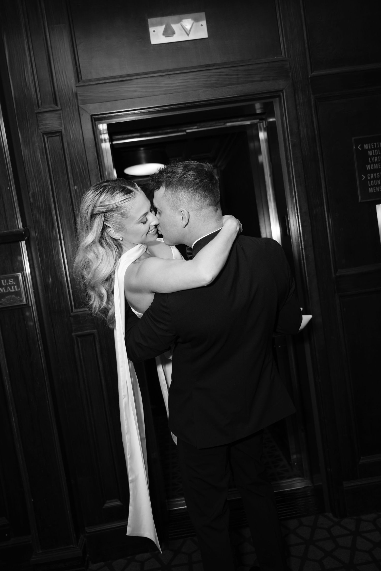 Dramatic black and white sequence capturing romantic moments in a dimly lit hallway.