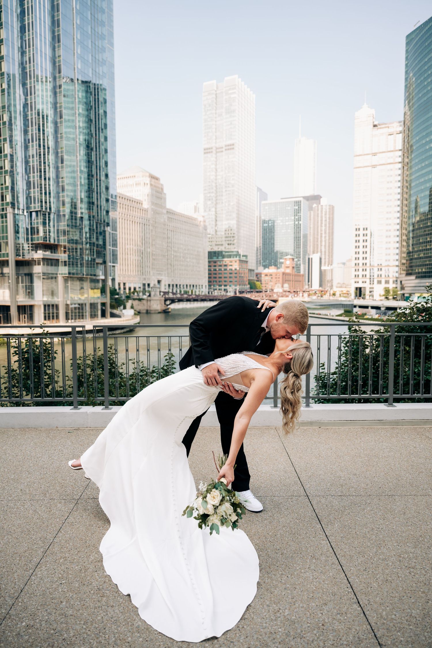 Dramatic urban wedding photos with the Chicago city skyline backdrop showing creative dips and poses.