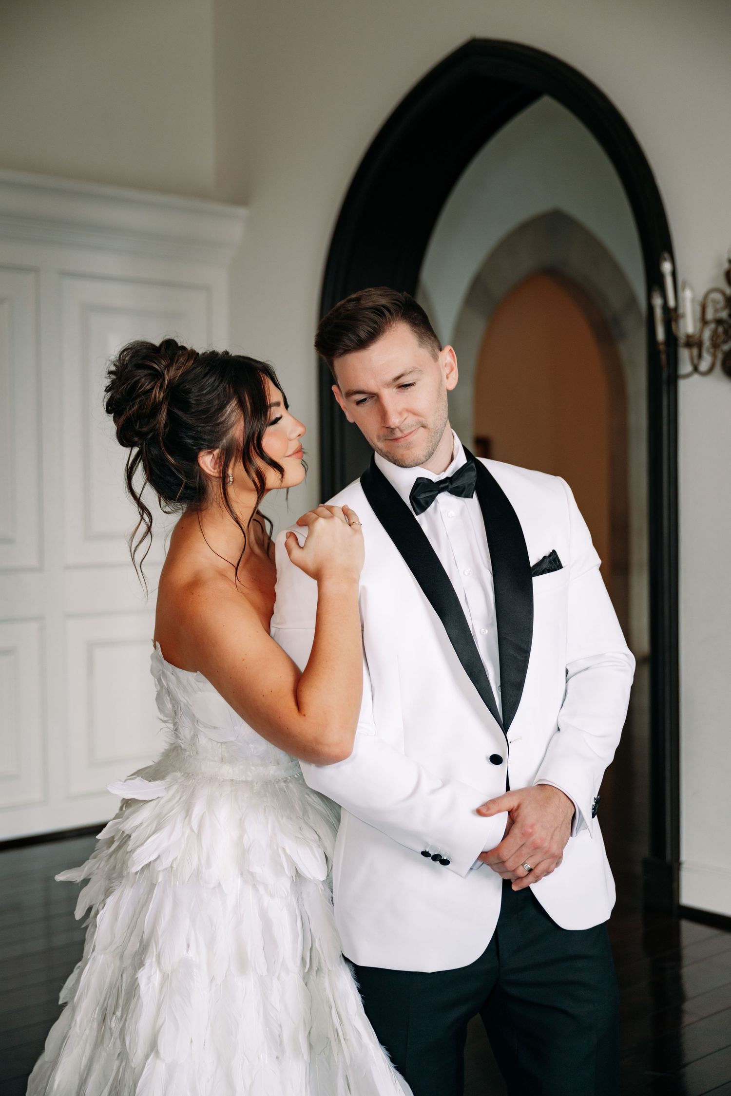 Romantic wedding couple sharing intimate moment in elegant white and black attire.