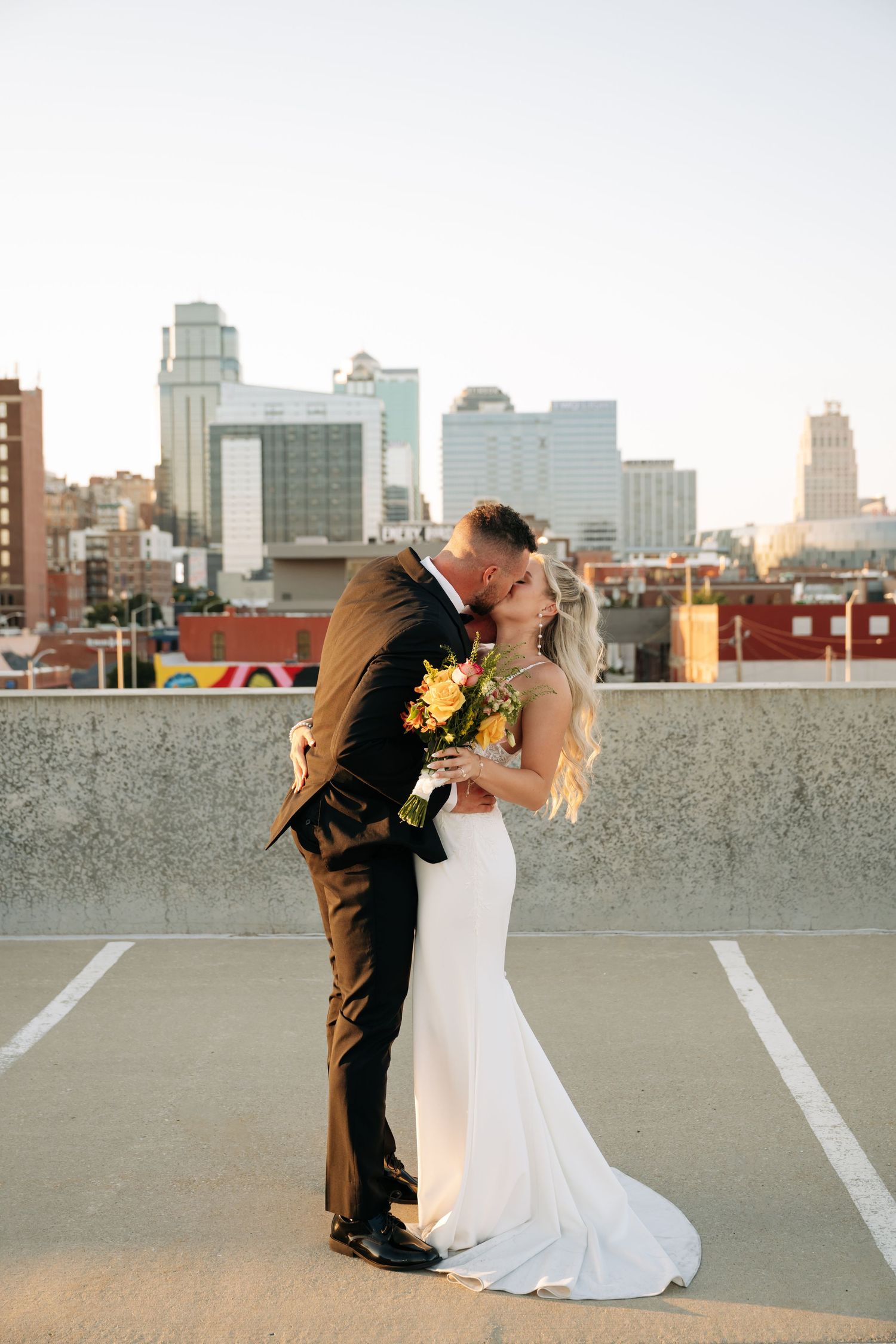 Romantic rooftop wedding photos with the Kansas city skyline at sunset.