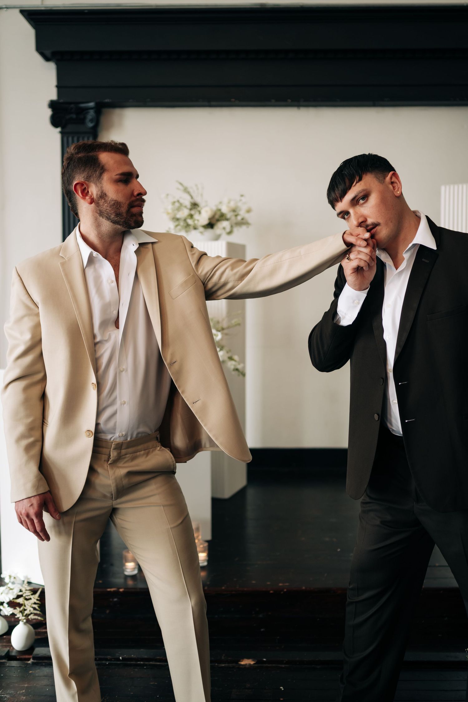 Groomsmen in tan and black suits interacting before the wedding ceremony.