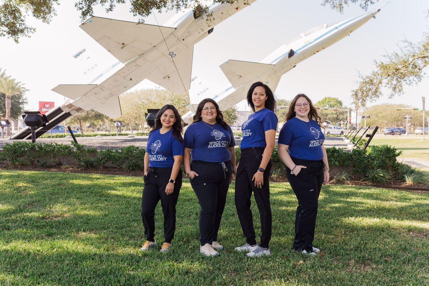 four women posing in front of rockets at space center Houston in nasa Houston Texas for their headshots