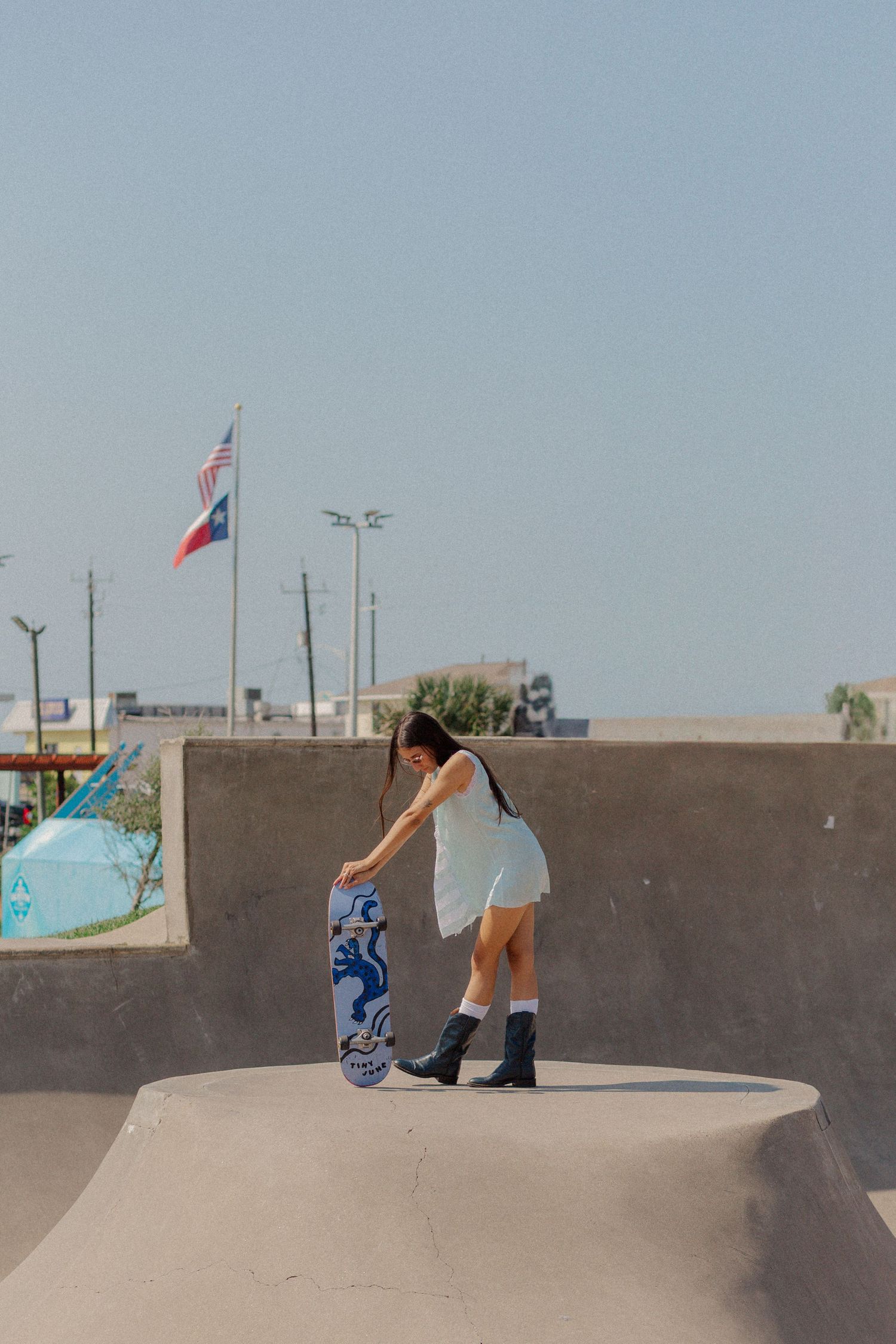hispanic girl with brown hair posing in an empty pool at a skate park in Galveston Texas for musician branding photo shoot
