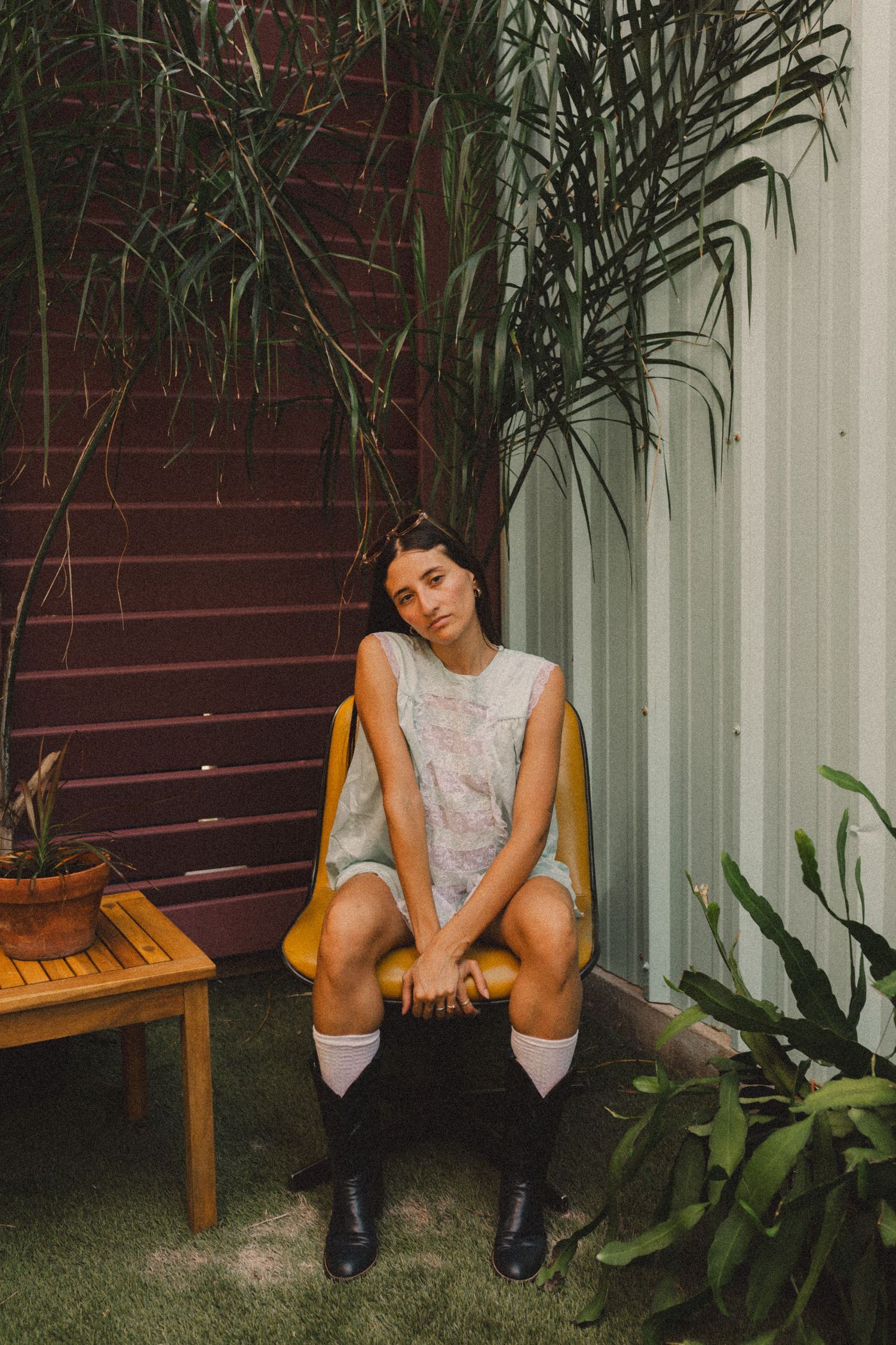 hispanic girl with brown hair posing on a chair in a coffee shop in Galveston Texas for musician branding photo shoot