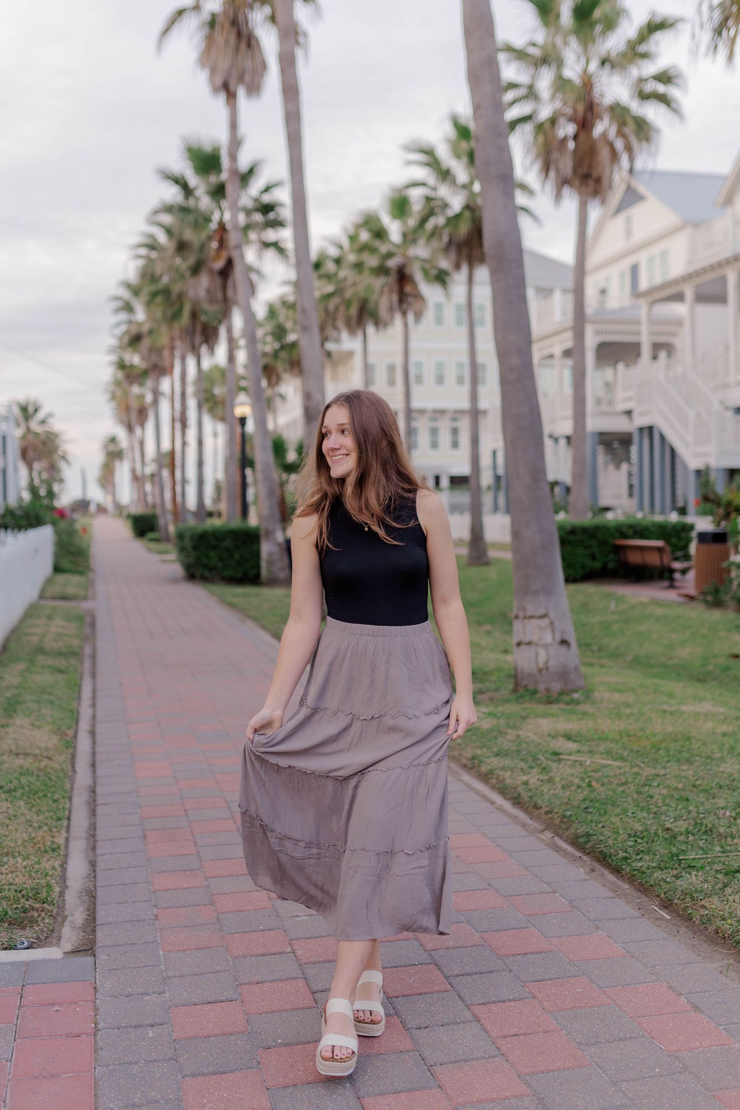high school senior girl walking through beach town neighborhood in Galveston Texas