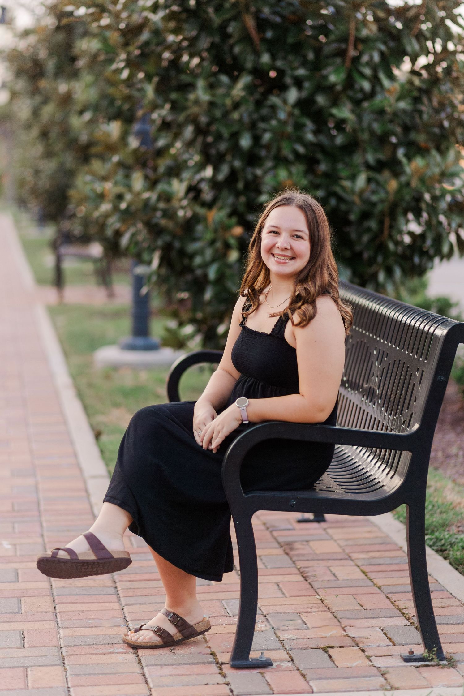 brunette white woman author posing on park bench in friendswood Texas for headshots
