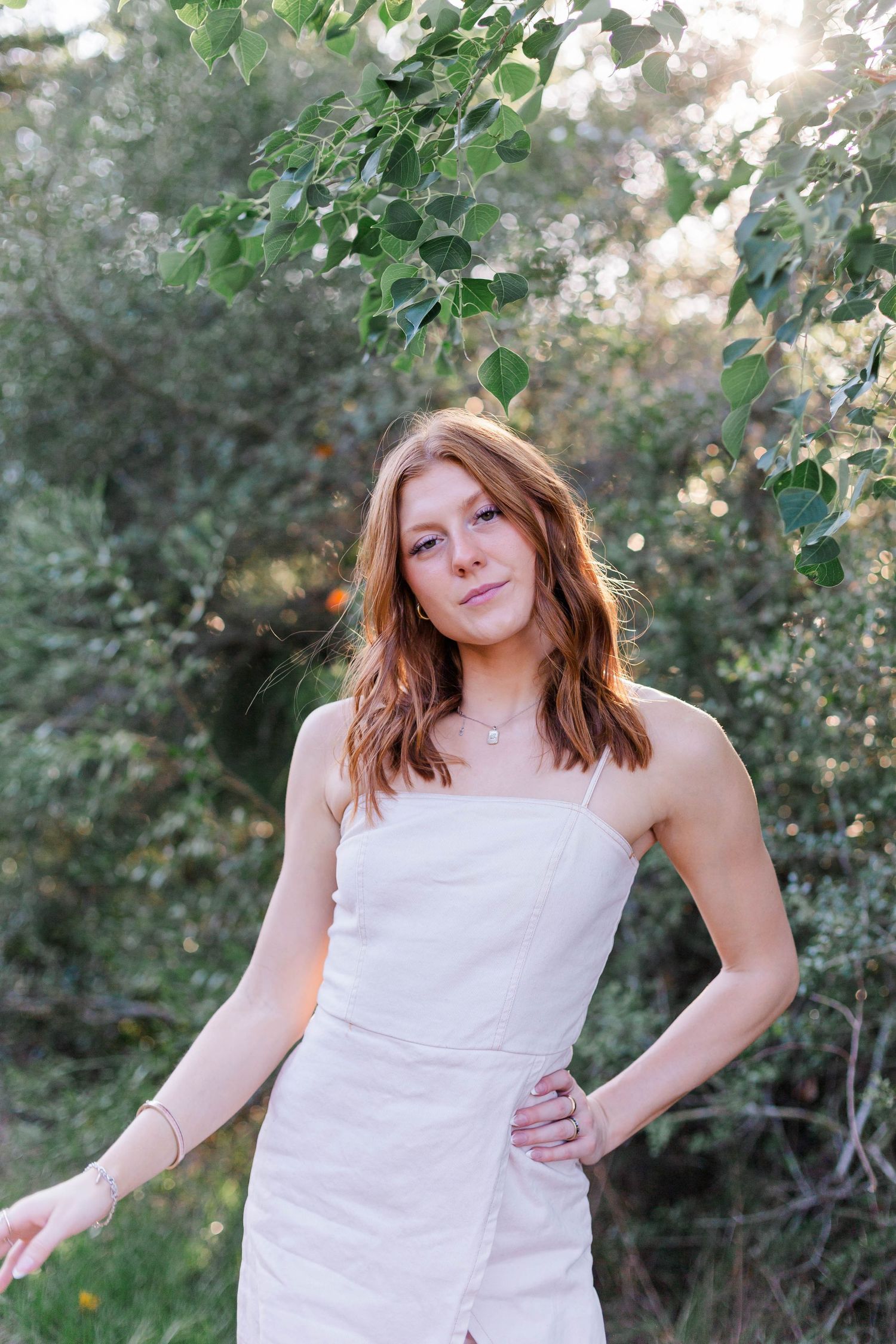high school senior poses in a field for senior photoshoot in friendswood Texas