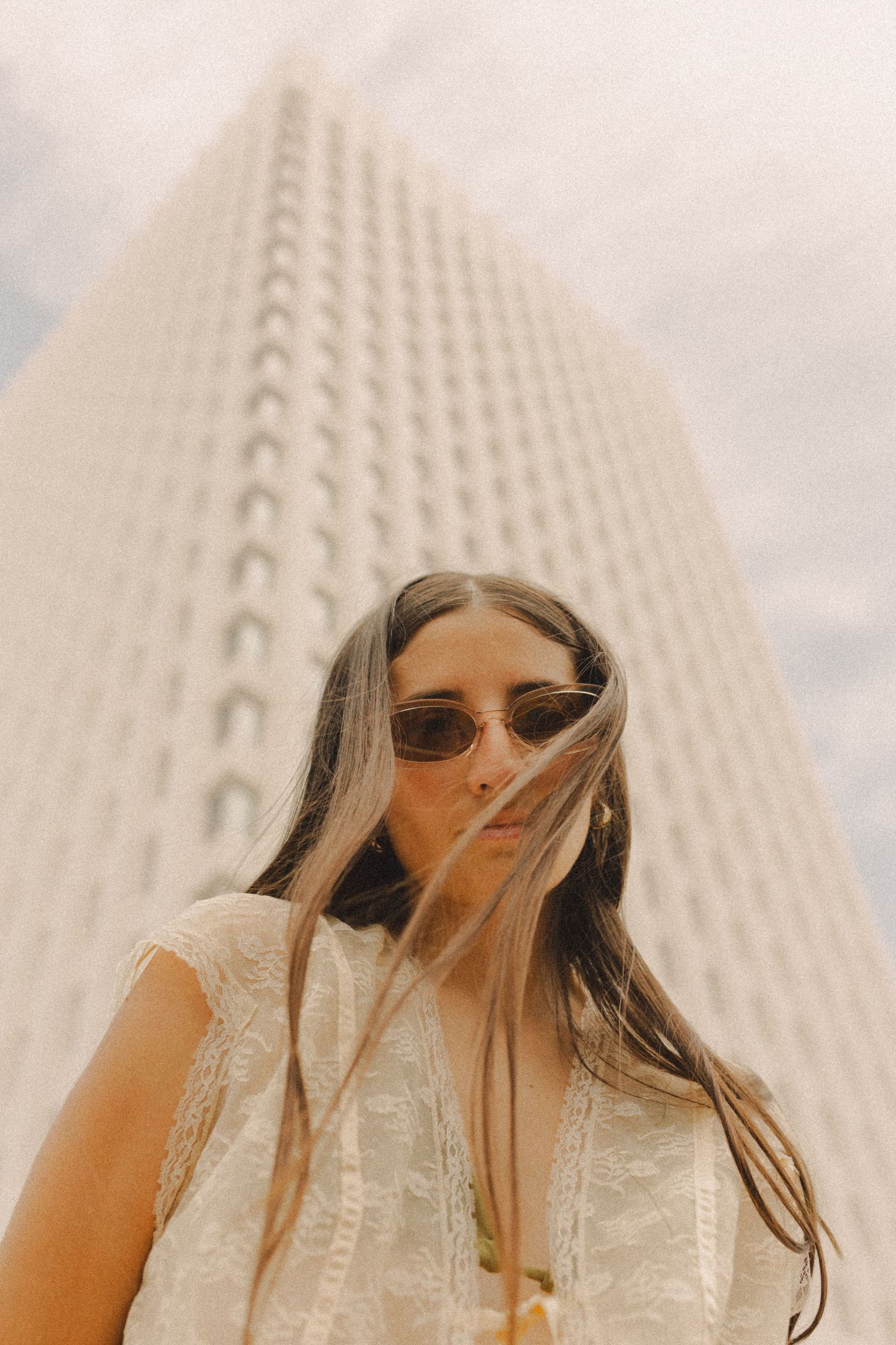 hispanic girl with brown hair posing in front of high rise building in Galveston Texas for musician branding photo shoot