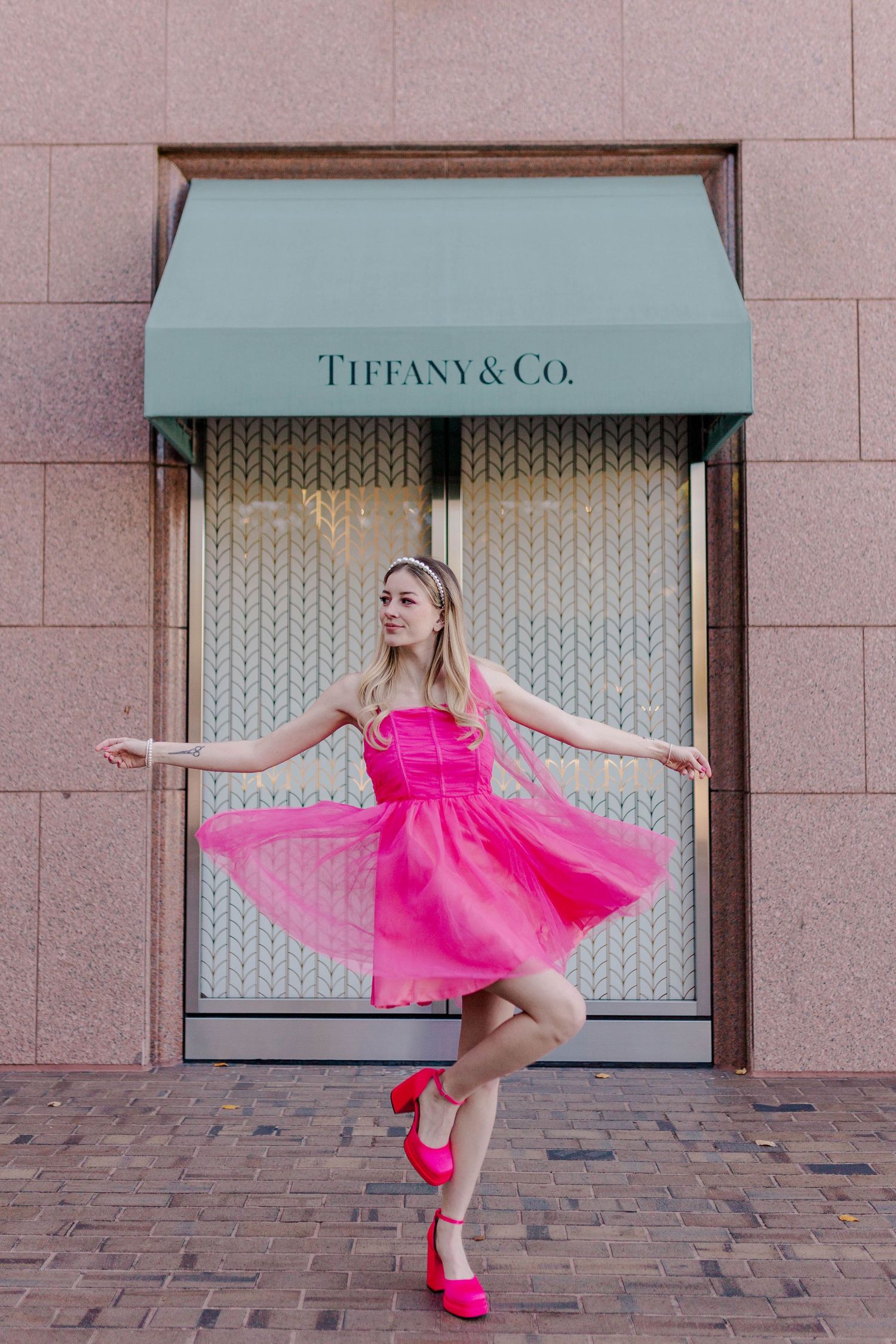 blonde model in hot pink dress and heels in front of Tiffany & Co at the Galleria in Houston, Texas for a barbie themed photoshoot