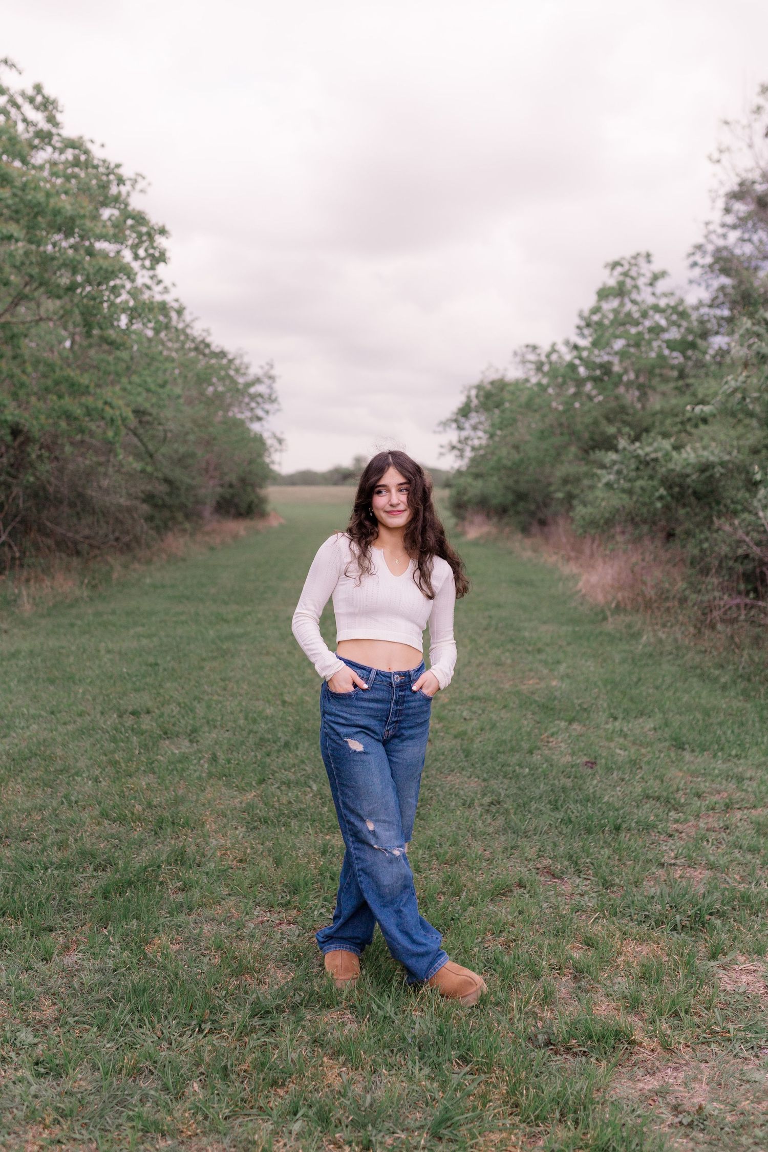 brunette white girl poses at a park in friendswood Texas for senior photos