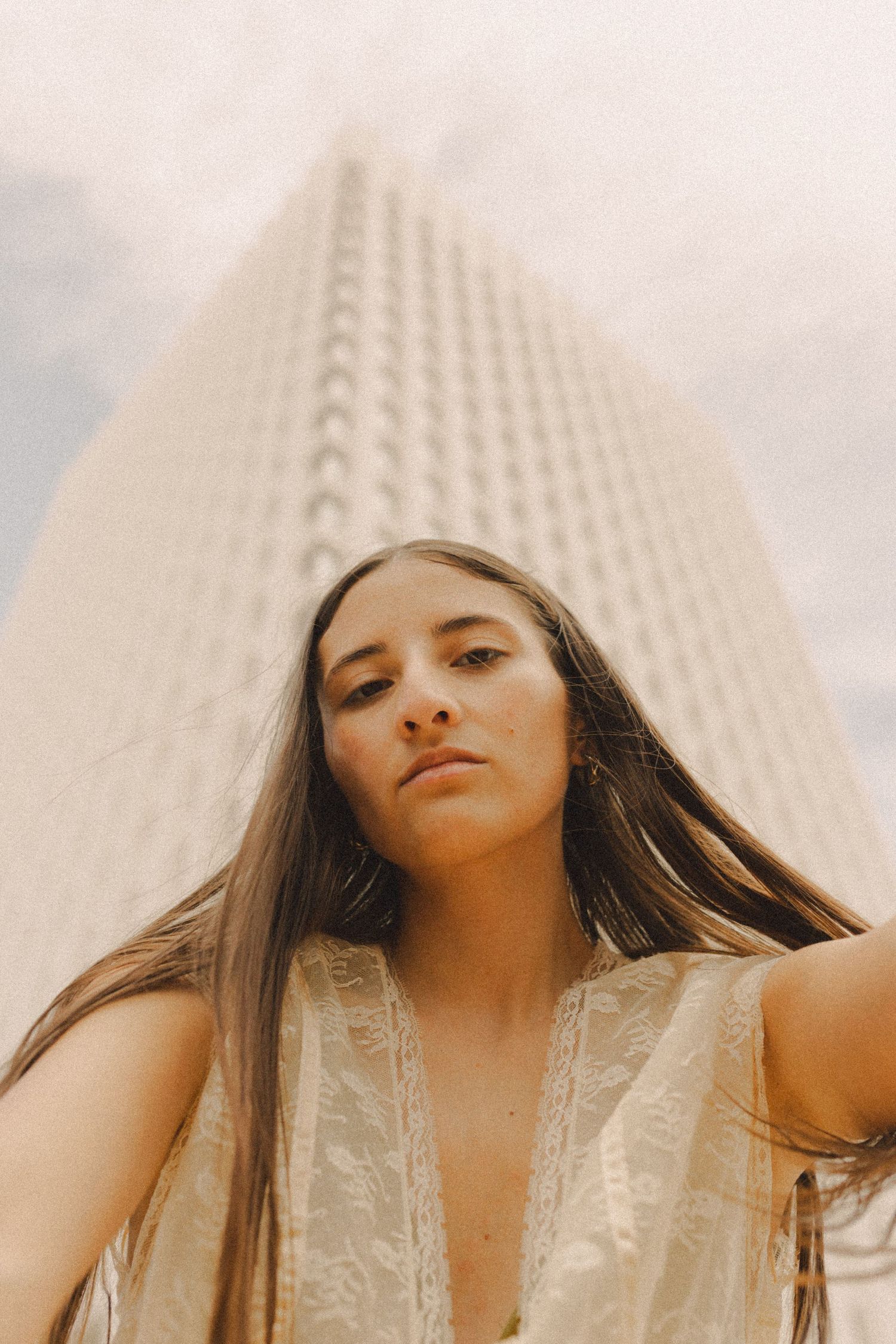hispanic girl with brown hair posing in front of high rise building in Galveston Texas for musician branding photo shoot