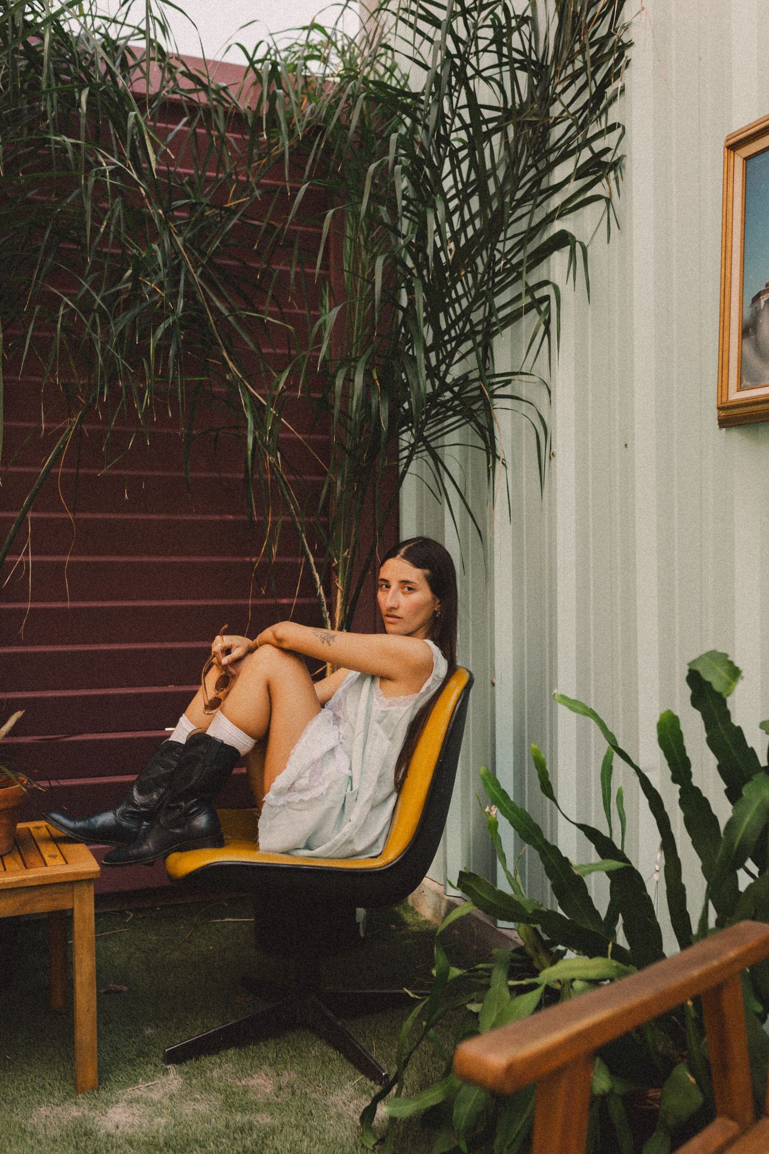 hispanic girl with brown hair posing on a chair in a coffee shop in Galveston Texas for musician branding photo shoot