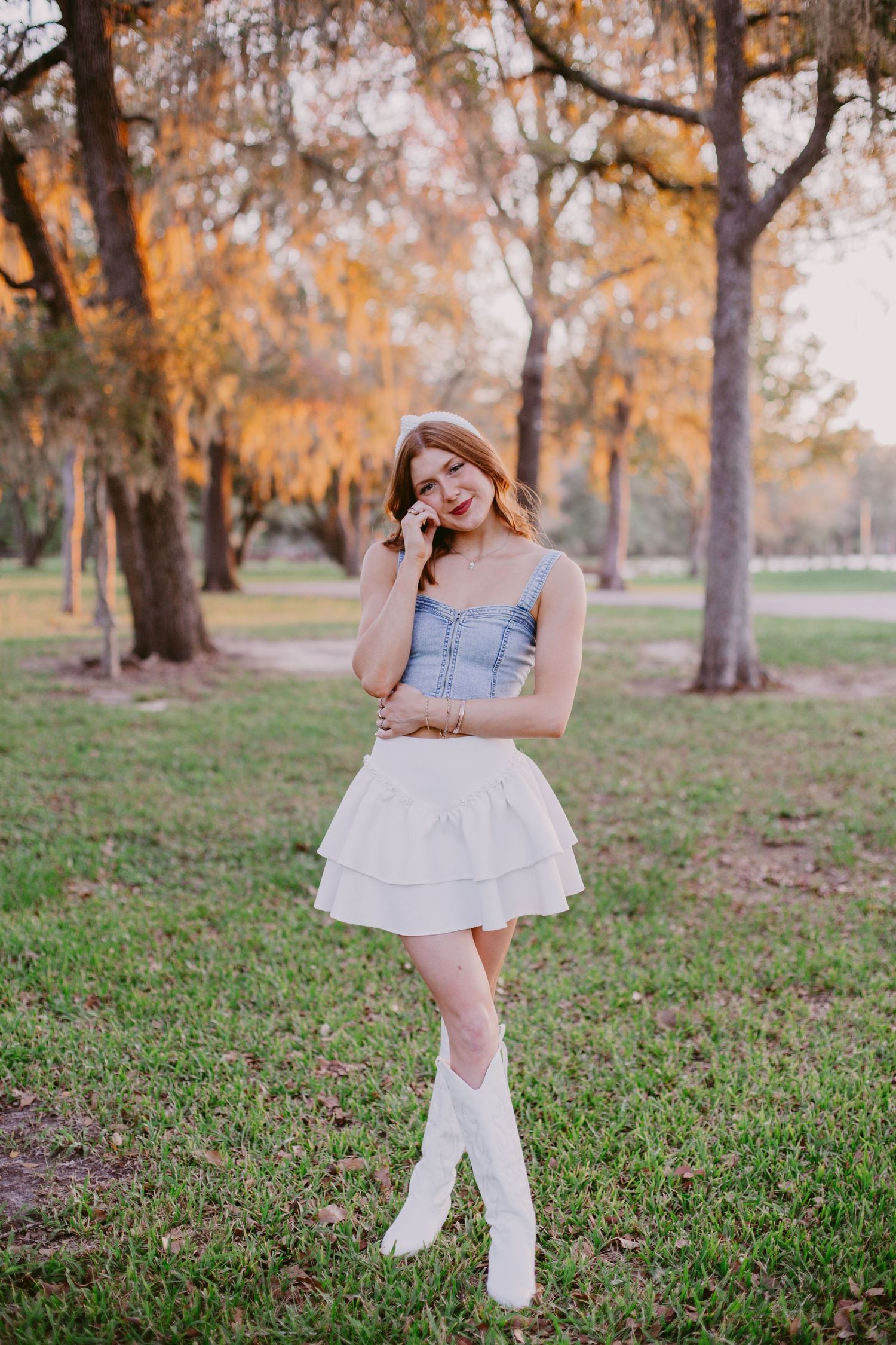 high school senior poses in a field for senior photoshoot in friendswood Texas