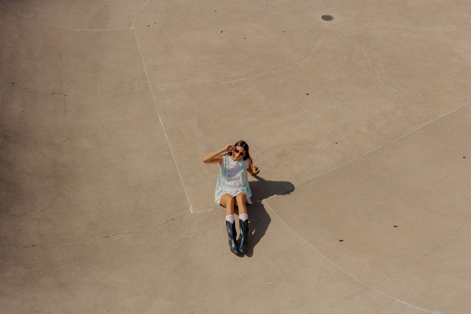 hispanic girl with brown hair posing in an empty pool at a skate park in Galveston Texas for musician branding photo shoot
