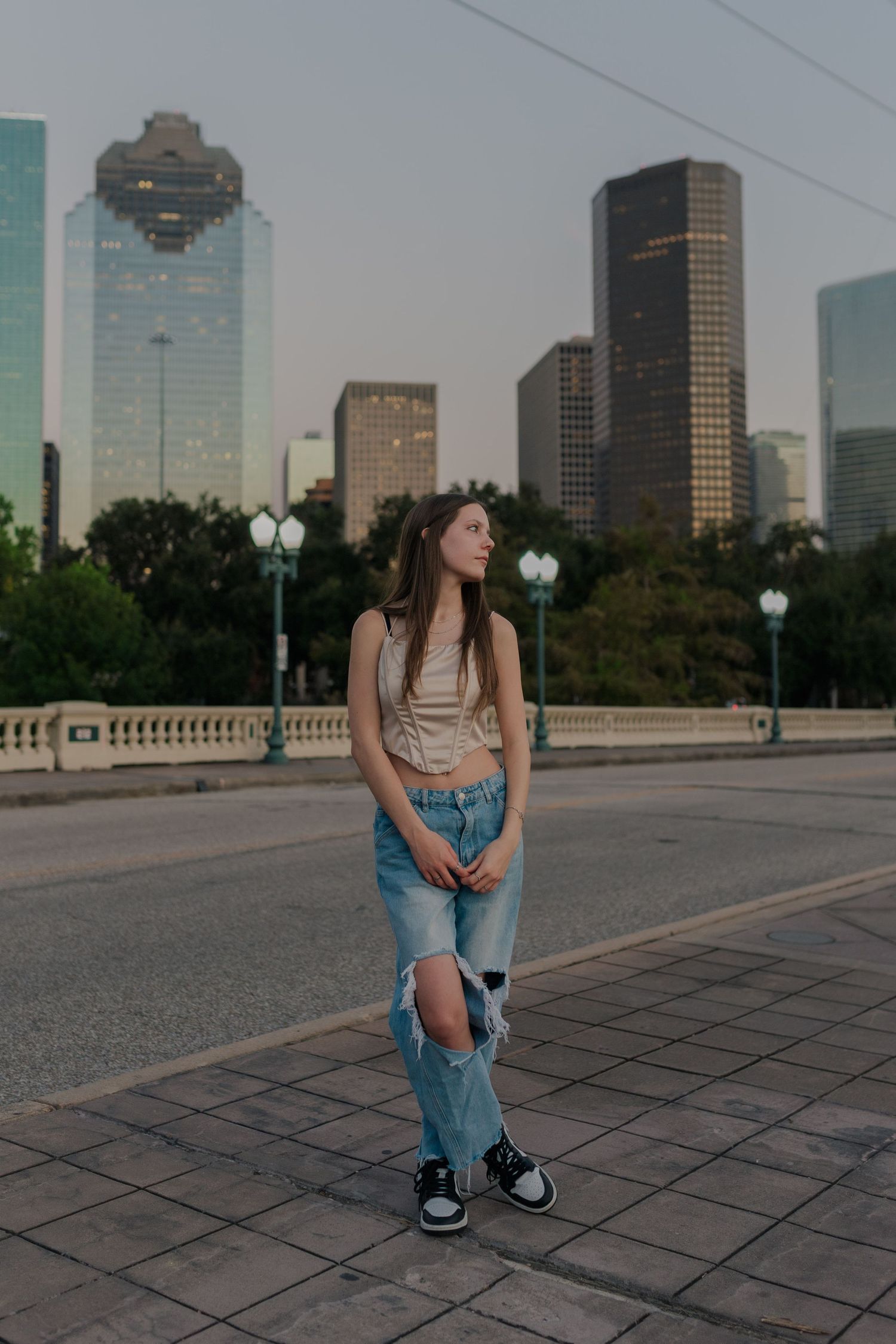 high school senior girl poses on sabine street bridge in downtown Houston Texas for senior photos