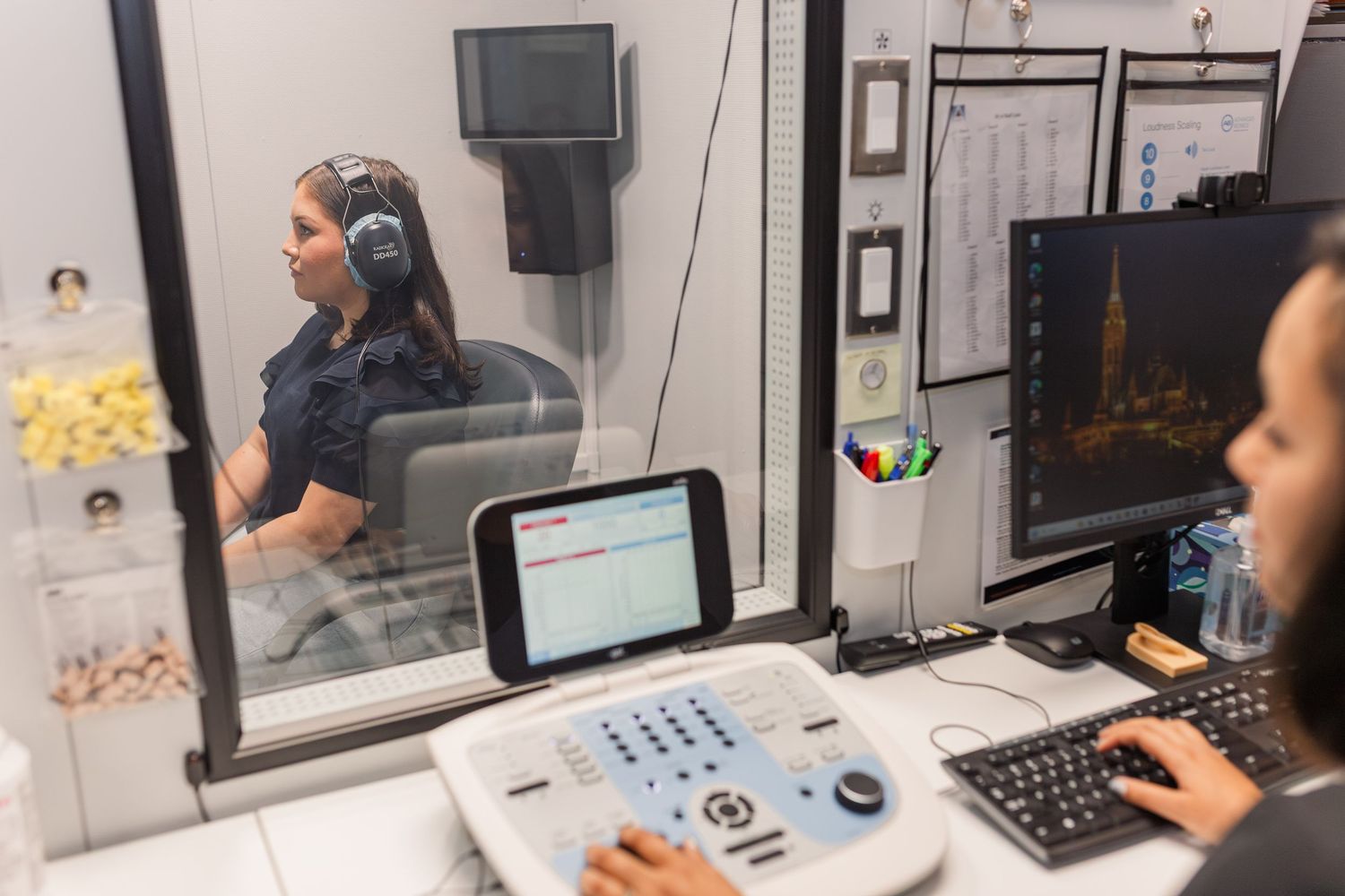 white woman poses for hearing test done by black audiologist in a branding business photoshoot